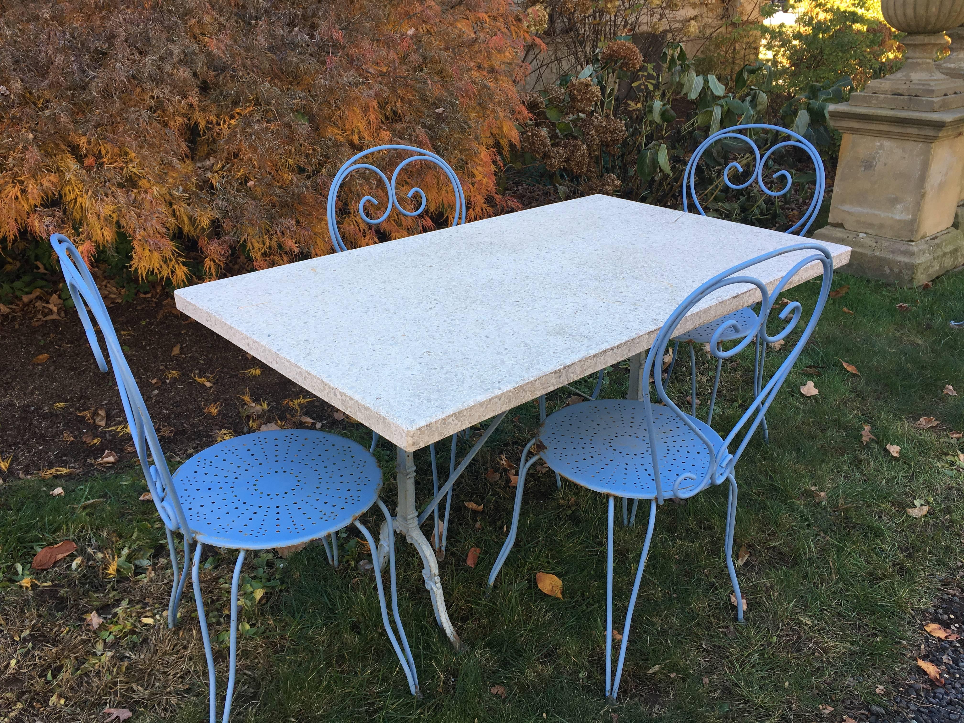 This is the smaller of the two identical French cast iron terrazzo-topped tables (signed Godin) that we have and is being sold with four French wrought iron chairs. Paint is in good antique condition, with normal weathering and fading to the base