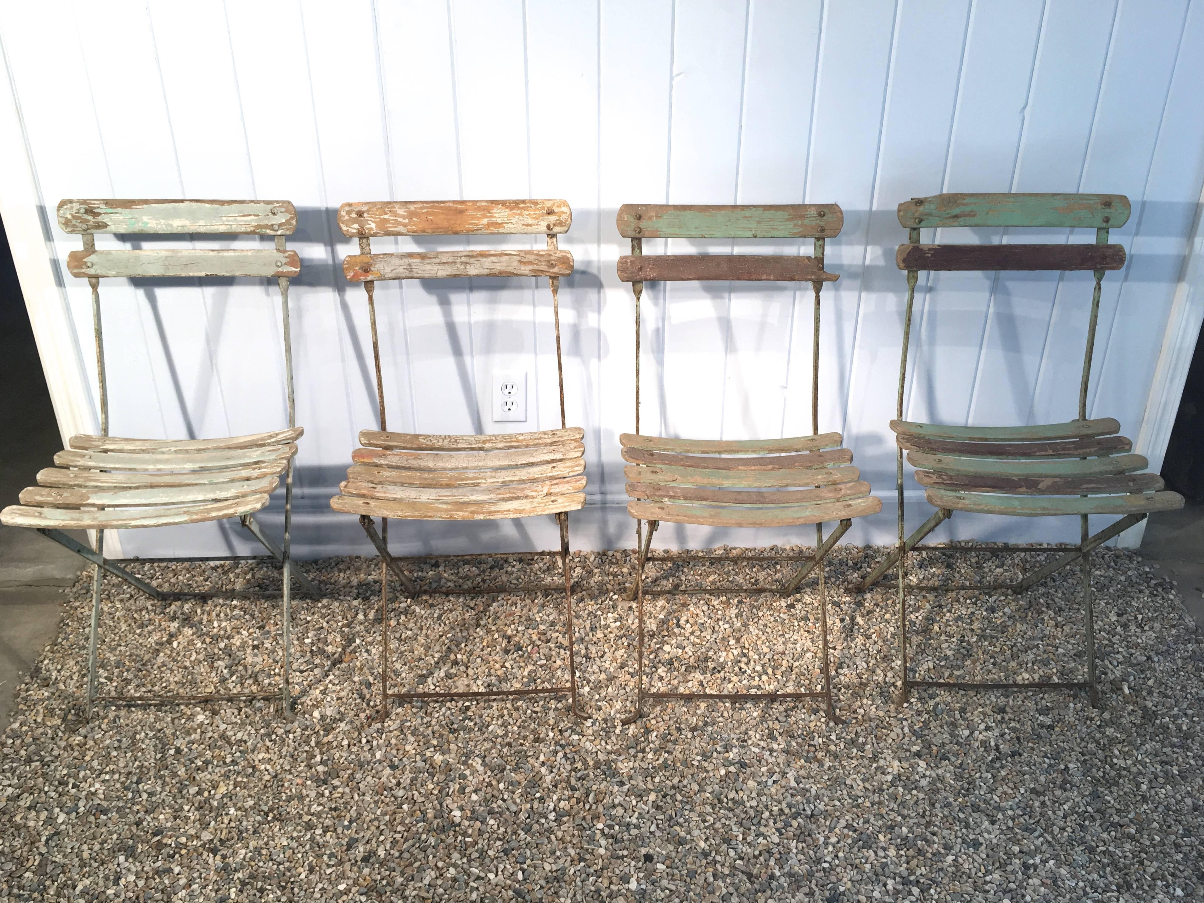 Great set of French folding wood (likely oak) and iron bistro chairs in faded pale blue/green paint with weathering. In great condition, except for a small missing piece to back slat on two chairs. Perfectly suited to indoor or outdoor use and they