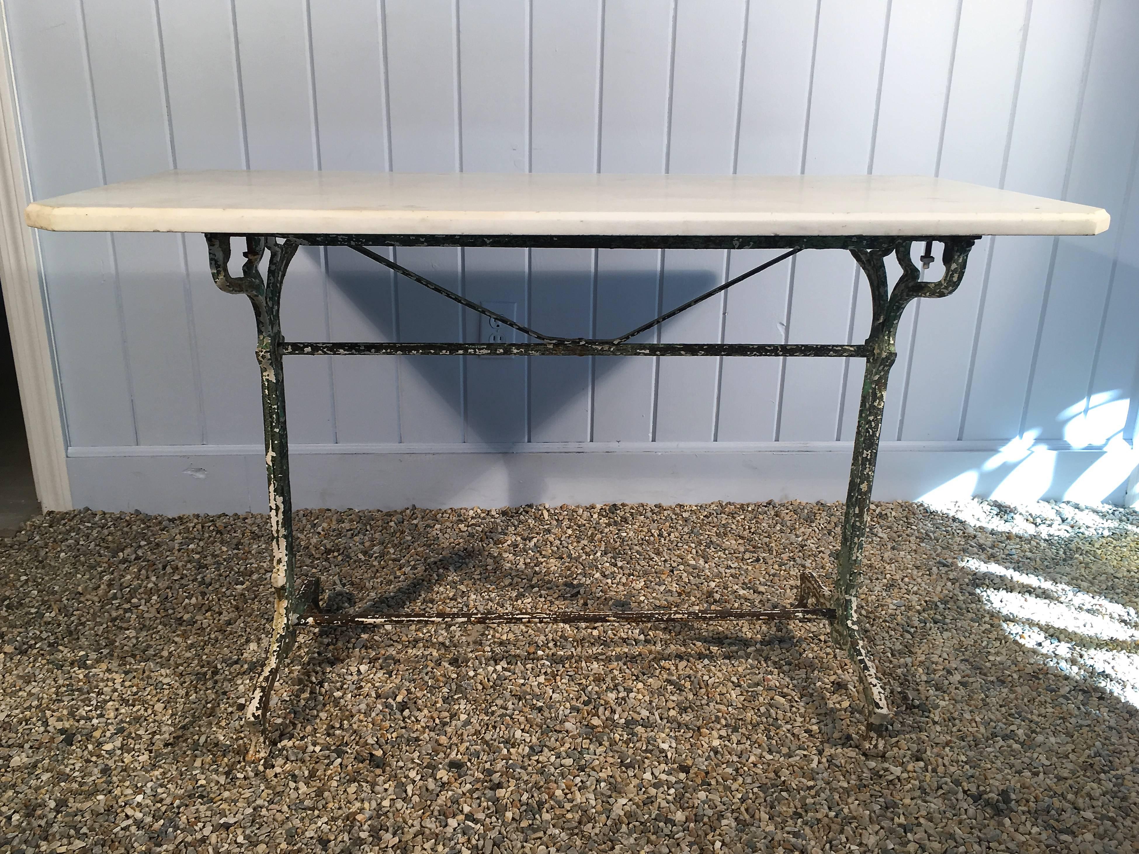 This fabulous cast iron Art Nouveau table base has a marvelous polychromed painted surface in green and white.  and features an antique white marble top, with beveled edge on three sides and cut corners. In very good antique condition overall