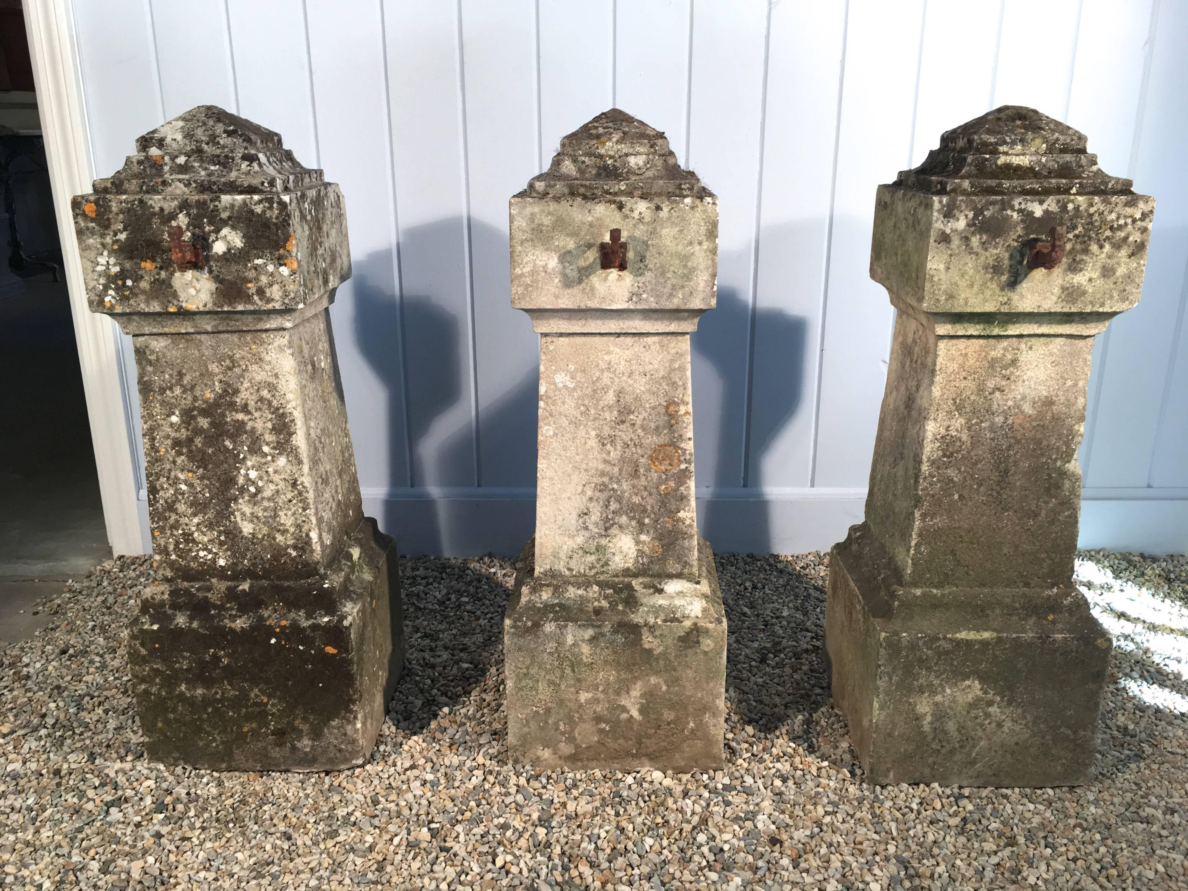 This is a rare and sensational set of three hand-carved 18th century French limestone entrance pillars/bollards with original wrought iron chain hooks that come with two pieces of 19th C hand-wrought heavy chain, each measuring 72 inches long.