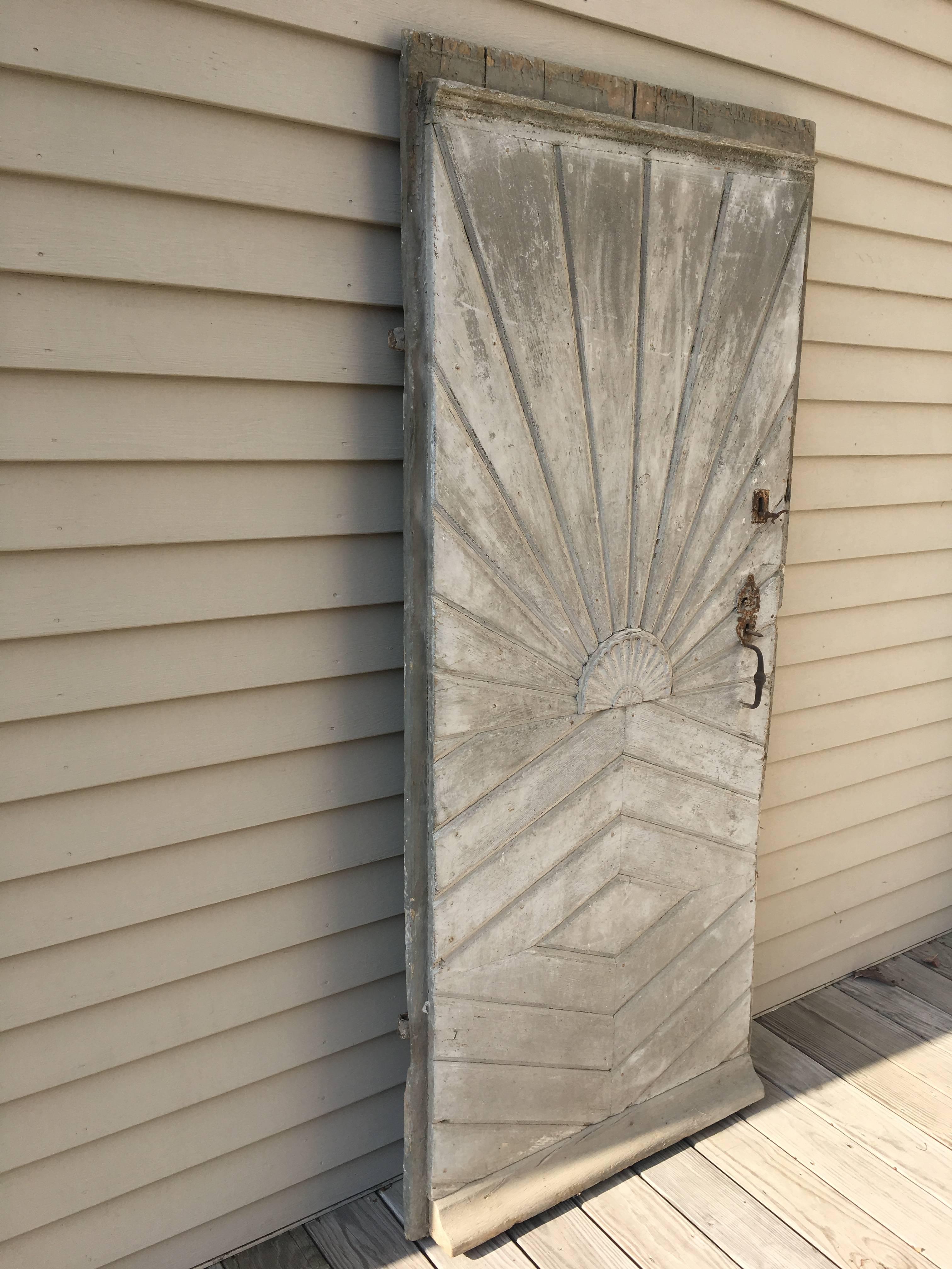 A stunning late 18th century oak and pine door with all original hand-forged strap hinges, iron lock, and keys, this sunburst and chevron-designed door would make a wonderful entrance to your secret garden. Old very pale grey paint on the exterior