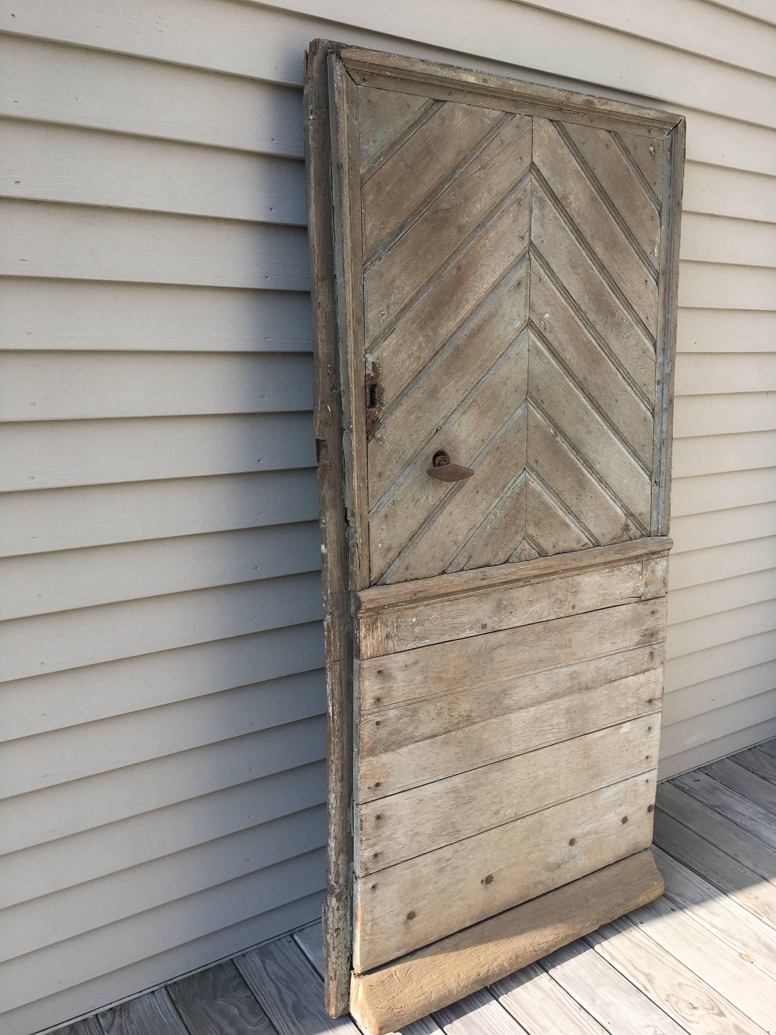 This beautiful and heavy door features a chevron design on its upper half with horizontal studded bottom. With its all original hand-forged strap hinges and handle, it would make a wonderful piece at the entrance to your walled garden or