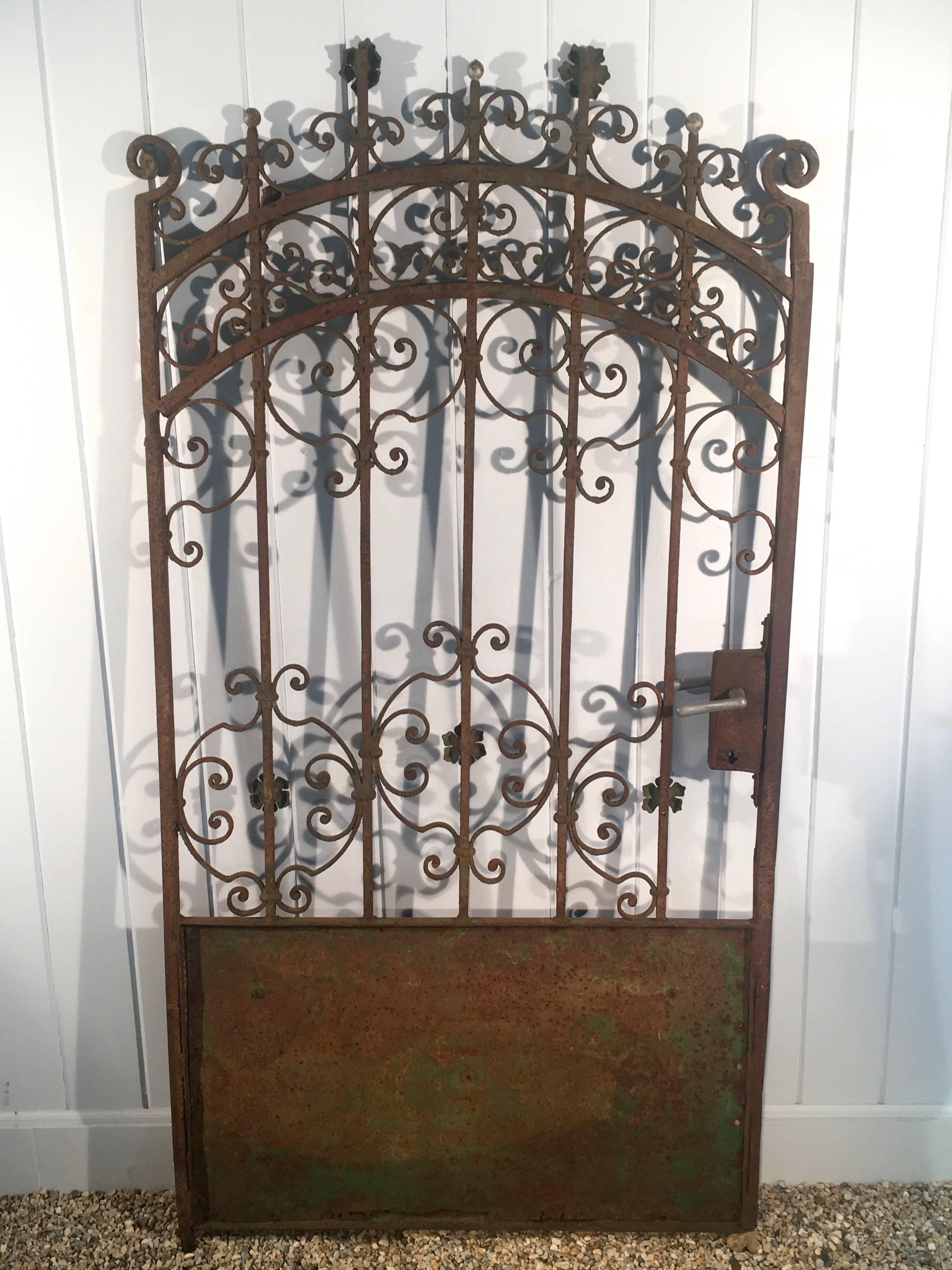 We love this French iron gate that dates to around 1890, particularly for its rusty surface with traces of old green and silver paint. Although the handle was replaced in the mid-20th century, it is purely decorative, as it is frozen at the present