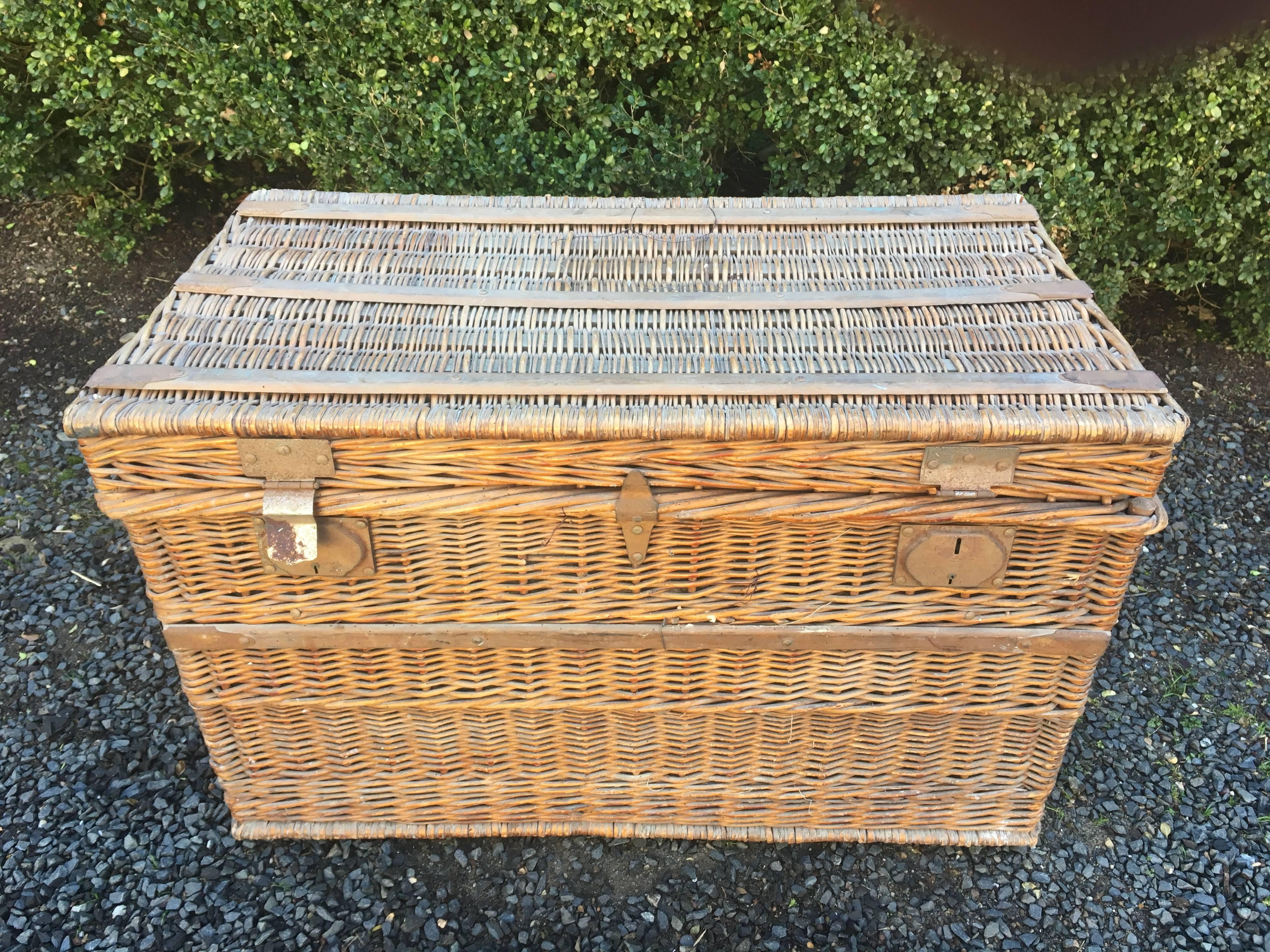 This commodious wicker trunk is a standout and features its original lining and handmade interior tray. Perfect for keeping those messy mudrooms tidy, or as a coffee table with storage. Overall in excellent condition, the lining has browned a bit