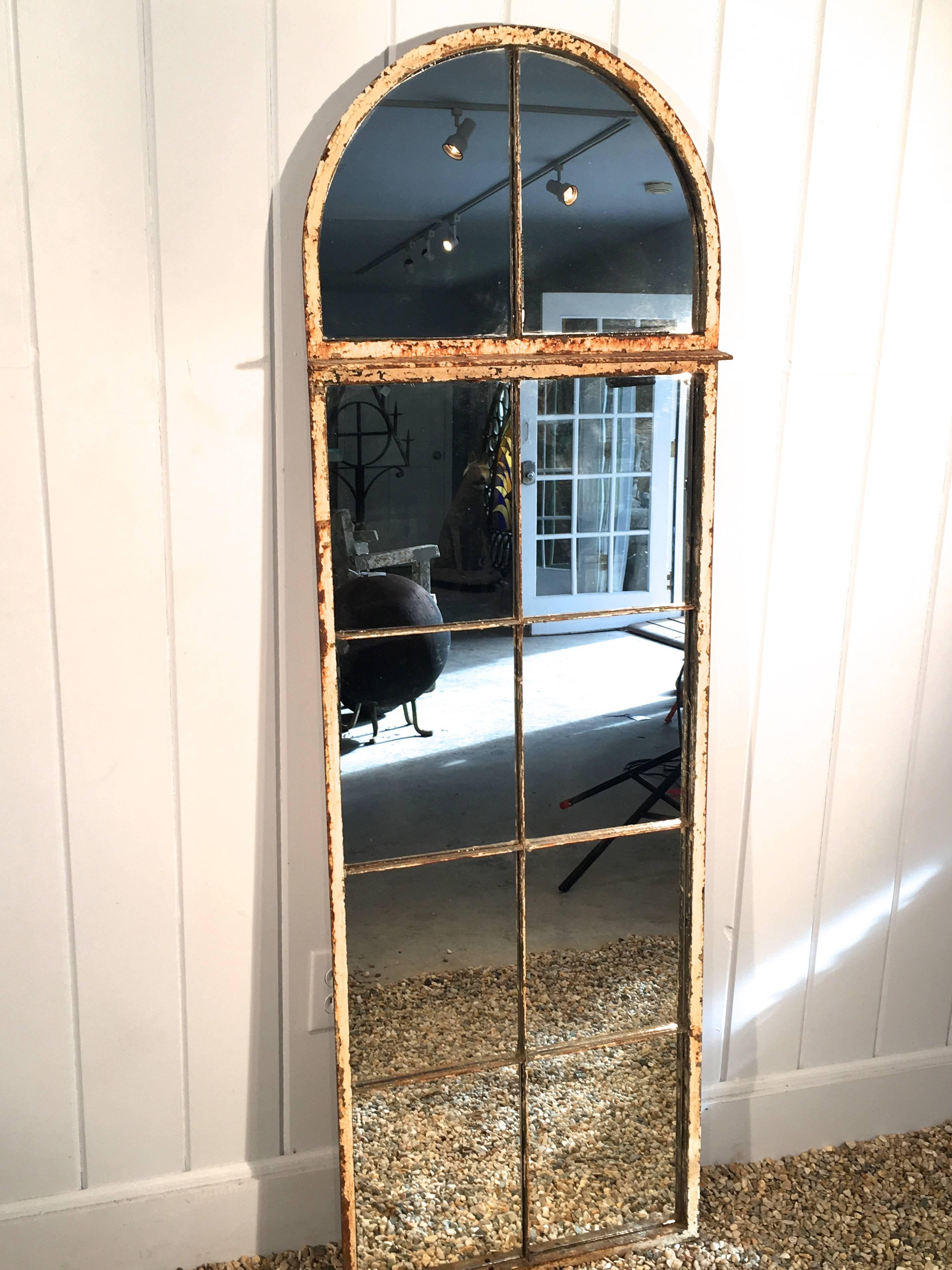 This lovely, early cast iron arched window frame has been transformed into a mirror that looks stunning above a console table, hanging in a bedroom or hallway, or in any space where an understated piece that brings light and reflection is called