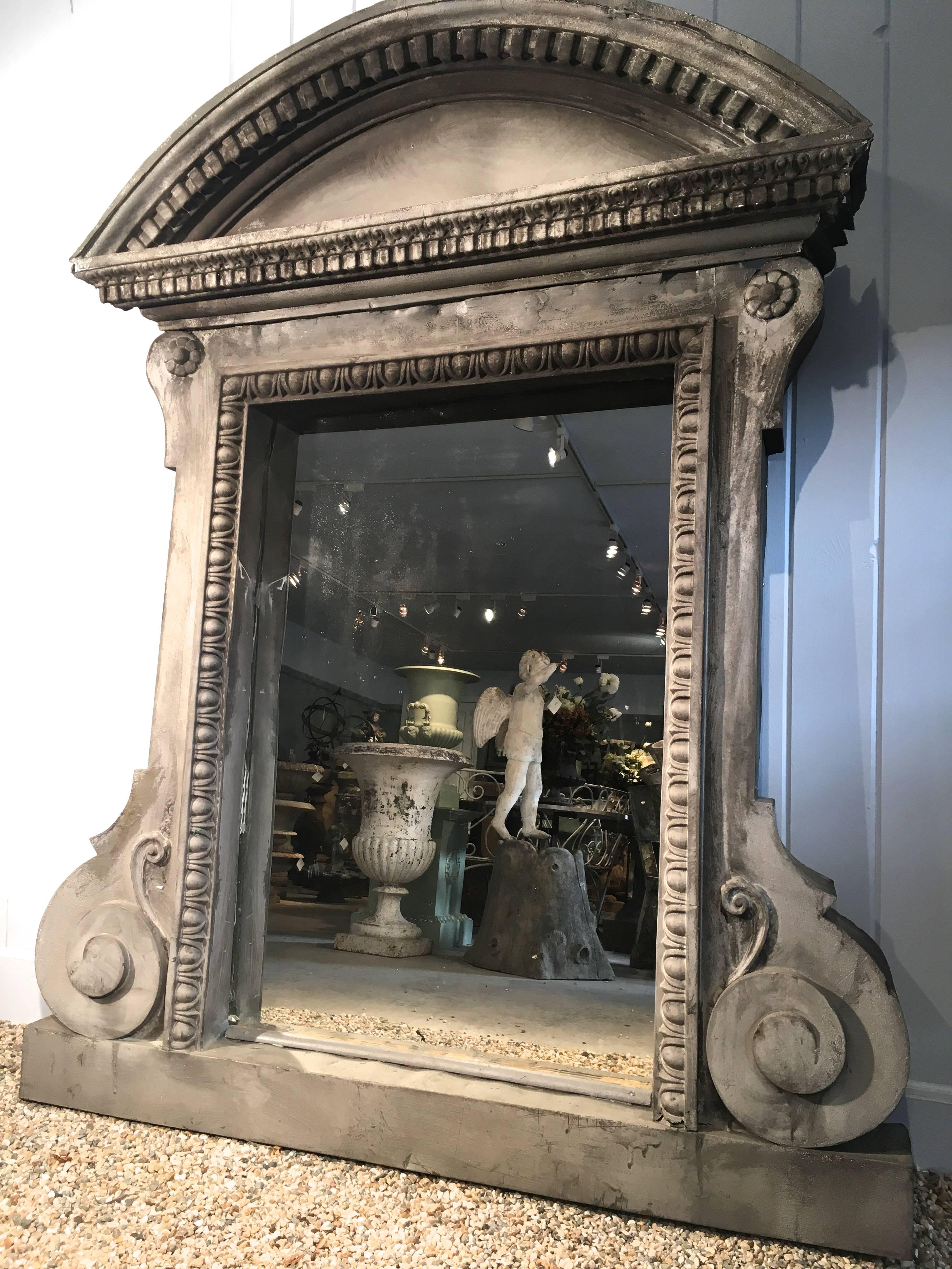 An extraordinary piece, this bold architectural mirror is made of zinc and features its original glass which is in very good condition for its age. The zinc frame has had a repair to the upper right edge but there remain a couple of small residual