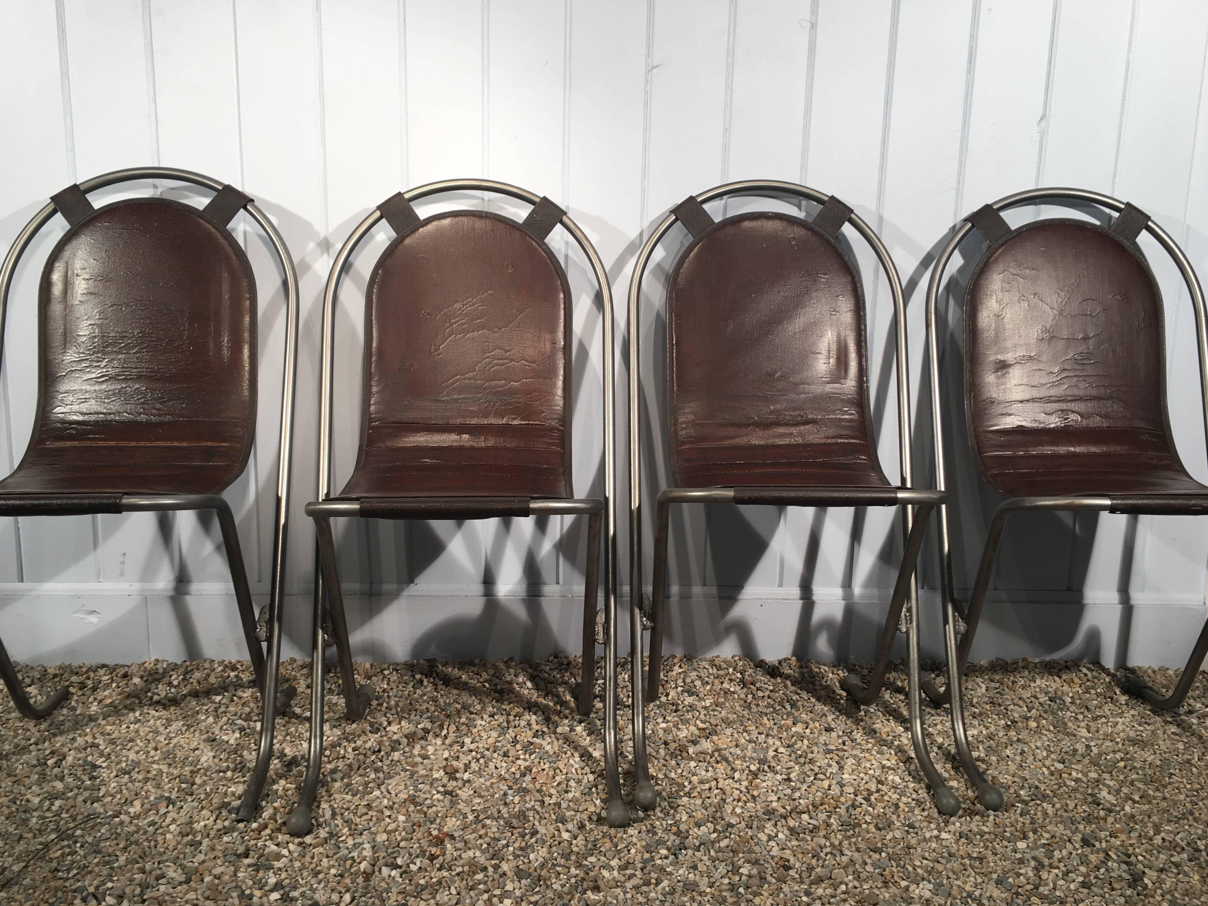 This sleek set of eight polished steel Stak-A-Bye chairs features their original snap-on brown Naugahyde seats and is quite rare. In immaculate condition, we have had the frames stripped and lacquered and the seats are in marvelous condition. What's
