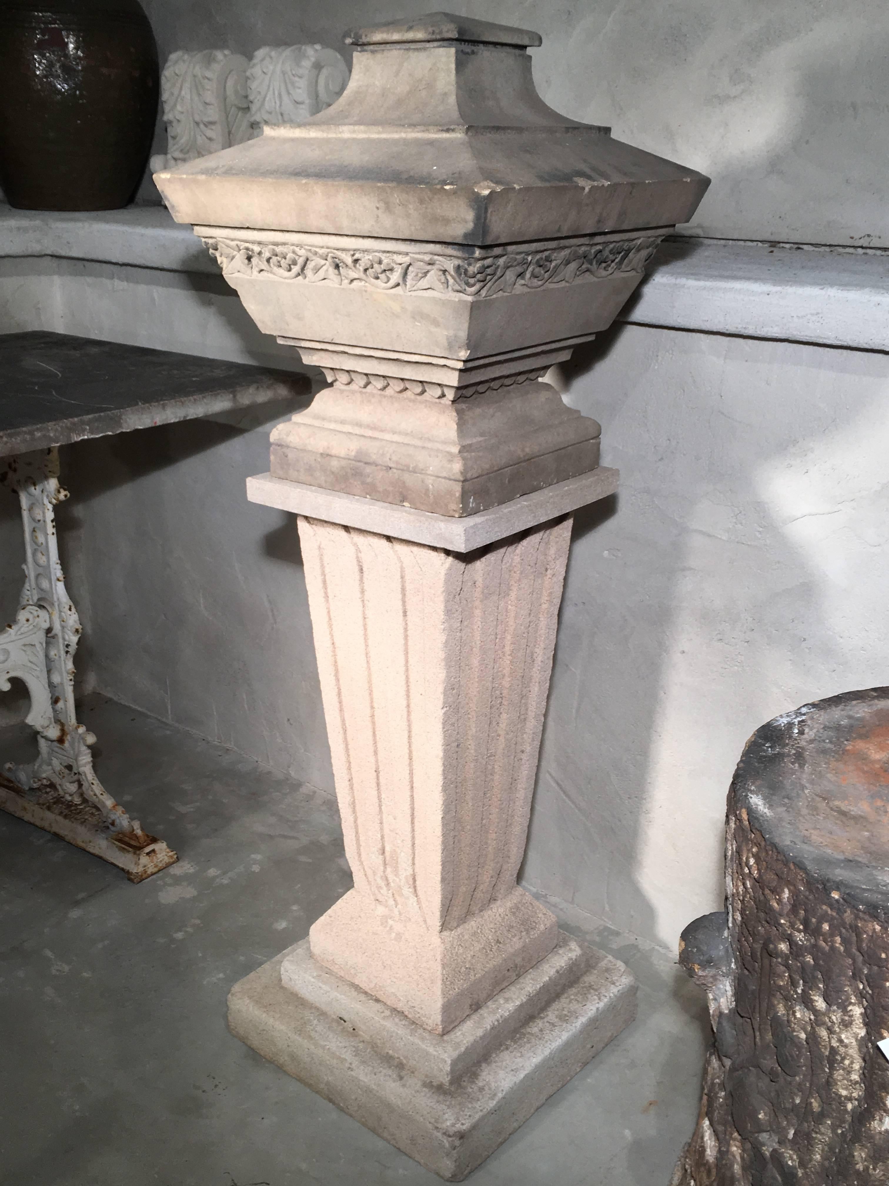 We have married this unusually shaped solid carved stone urn dating from the mid-1800s with a tall cast stone pedestal with tapering rectangular fluted form. The urn has wonderful carving on all four sides and both pieces are in excellent condition.
