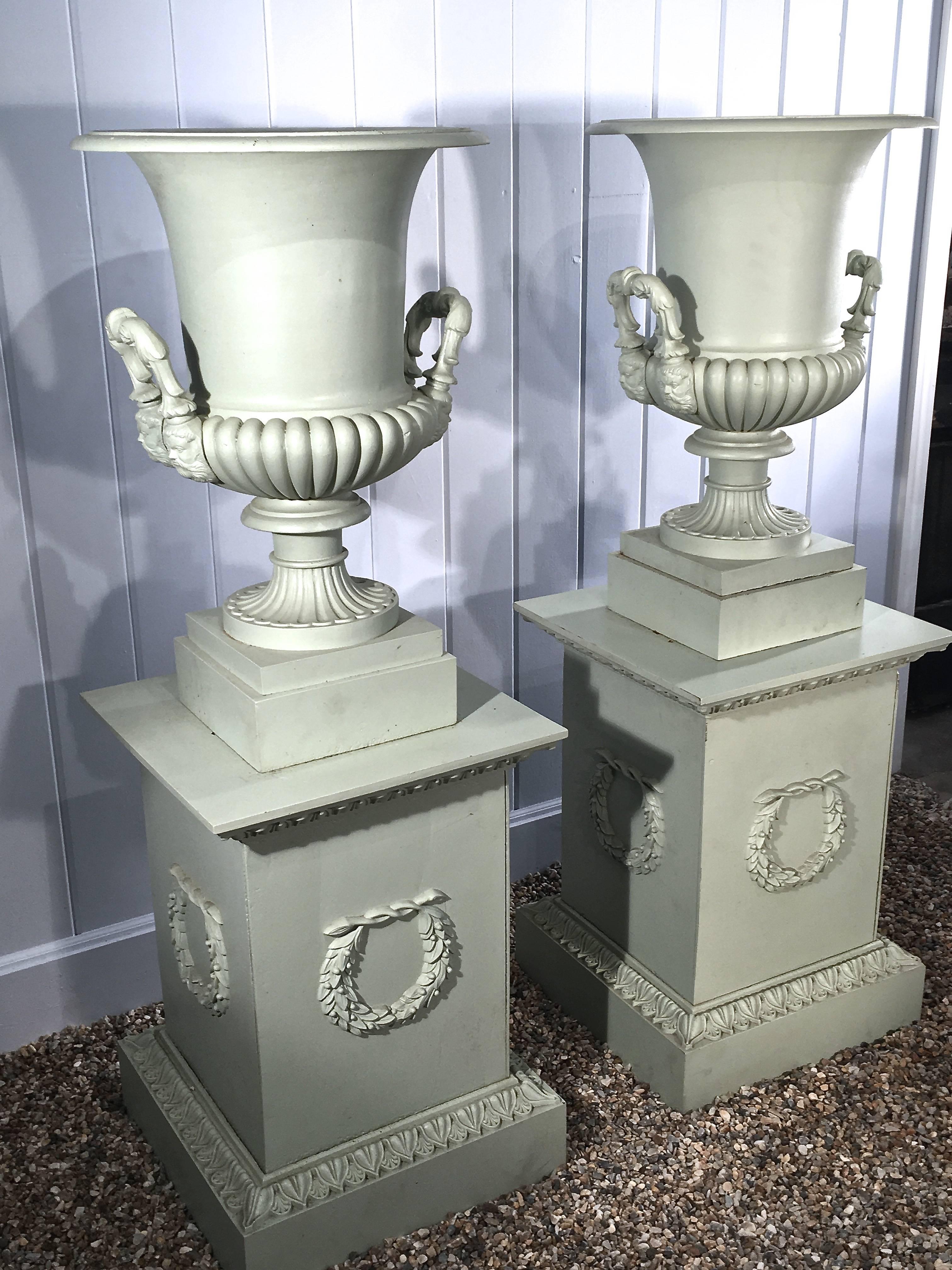 Neoclassical Revival Pair of 19th Century French Cast Iron Masked Urns on Tall Plinths