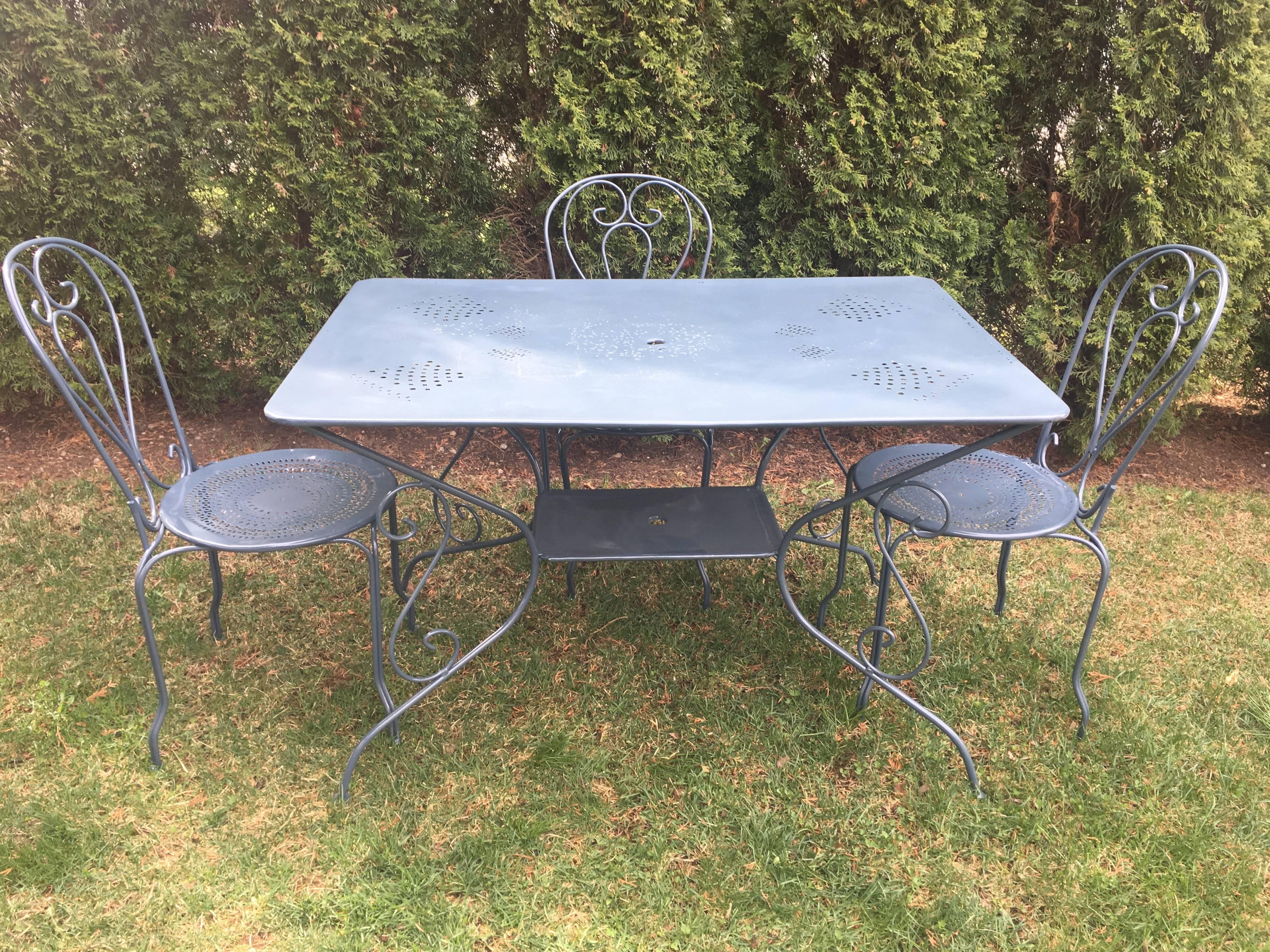 This classic French garden table and chairs set will give you years of pleasurable outdoor dining on your patio or terrace. The two-tier rectangular table features a lovely pierced design of various sized urns, and the four matching chairs are