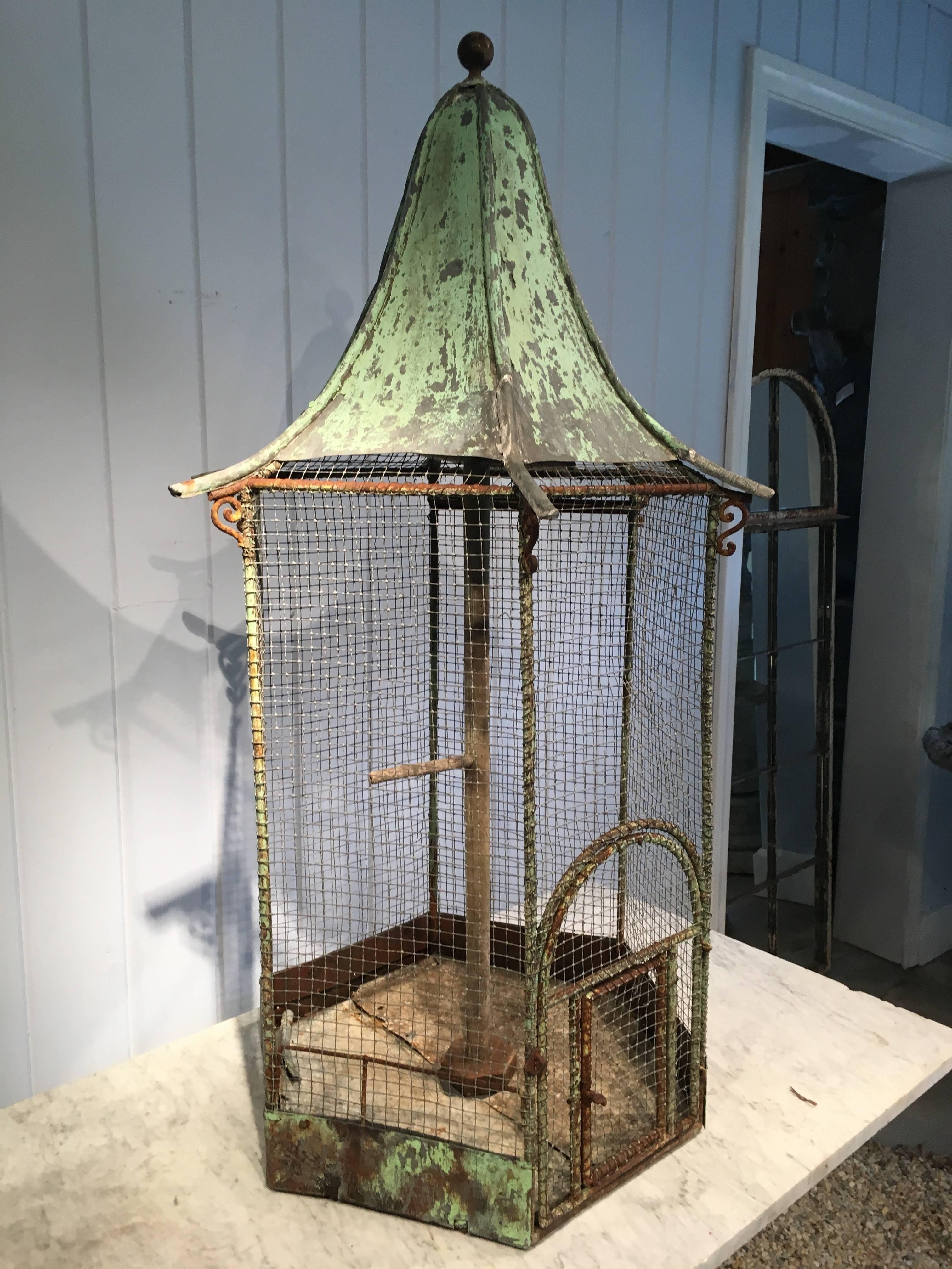 We adore the weathered green painted surface of this unusual hexagonal-shaped zinc birdcage as well as its all-original condition. The pagoda-shaped roof with round finial is stunning and has lovely outwardly-sloping edges with little scrolled