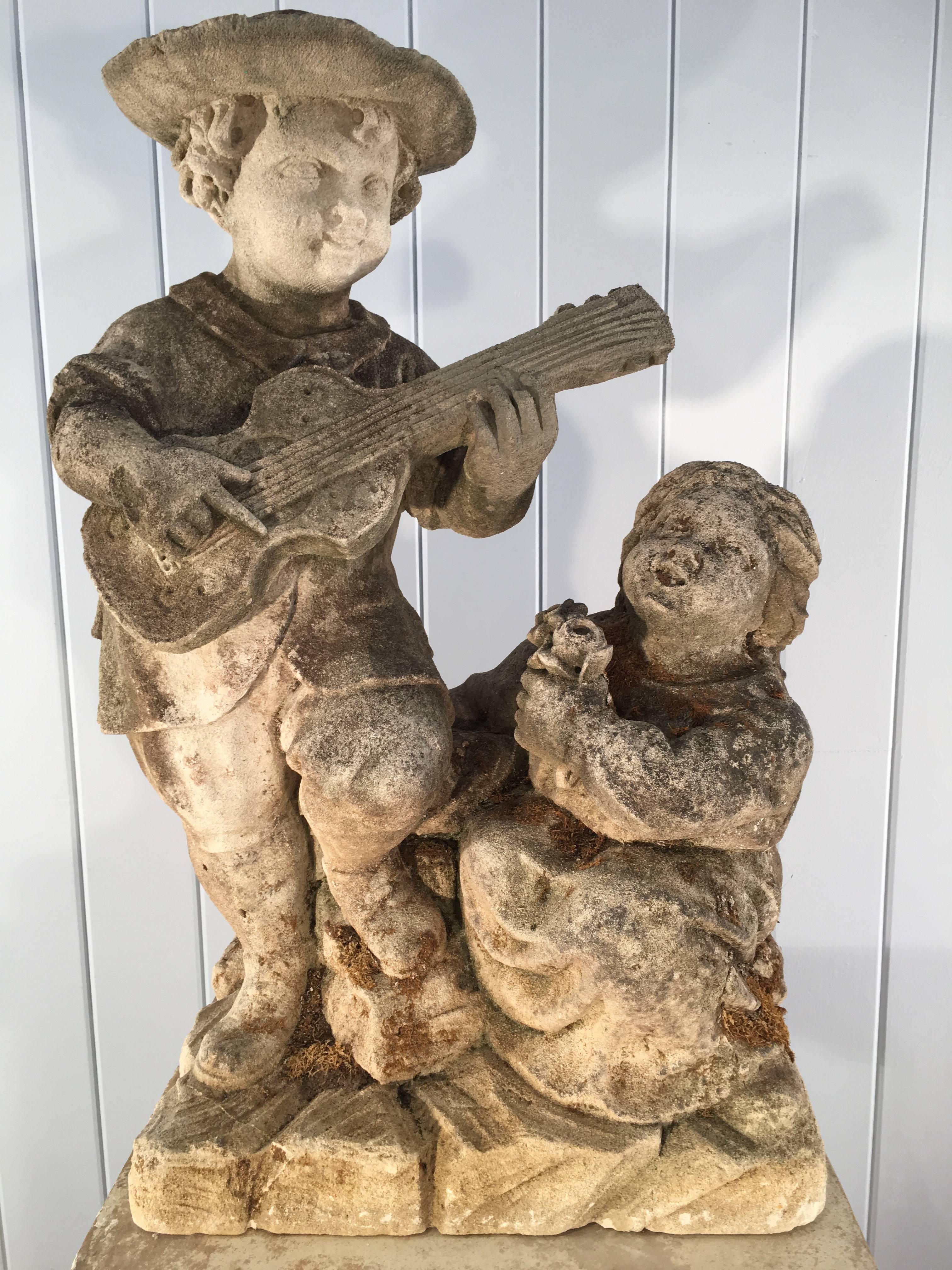 What a charming piece and quite rare! This beautifully-carved statue is most probably from the Low Countries (Netherlands, Belgium, Luxembourg) and features a young boy with mandolin serenading his little sister. She gazes upwards adoringly at him,