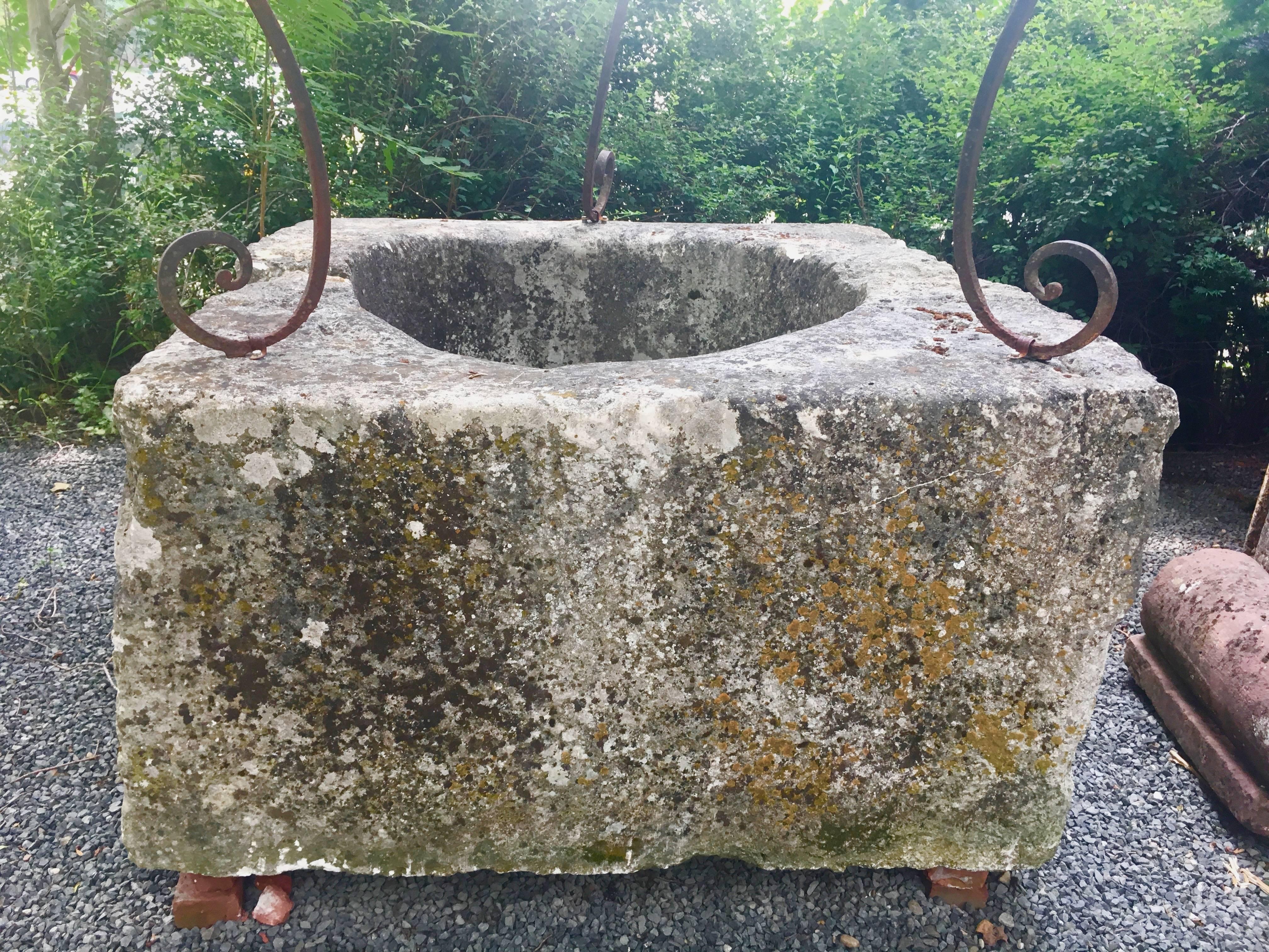 If you are looking for a wellhead with everything you could want, this is it! Carved by hand in the 18th century from a single block of stone (Calcaire de Vendée) and then separated into two halves to make it transportable, the wellhead features the