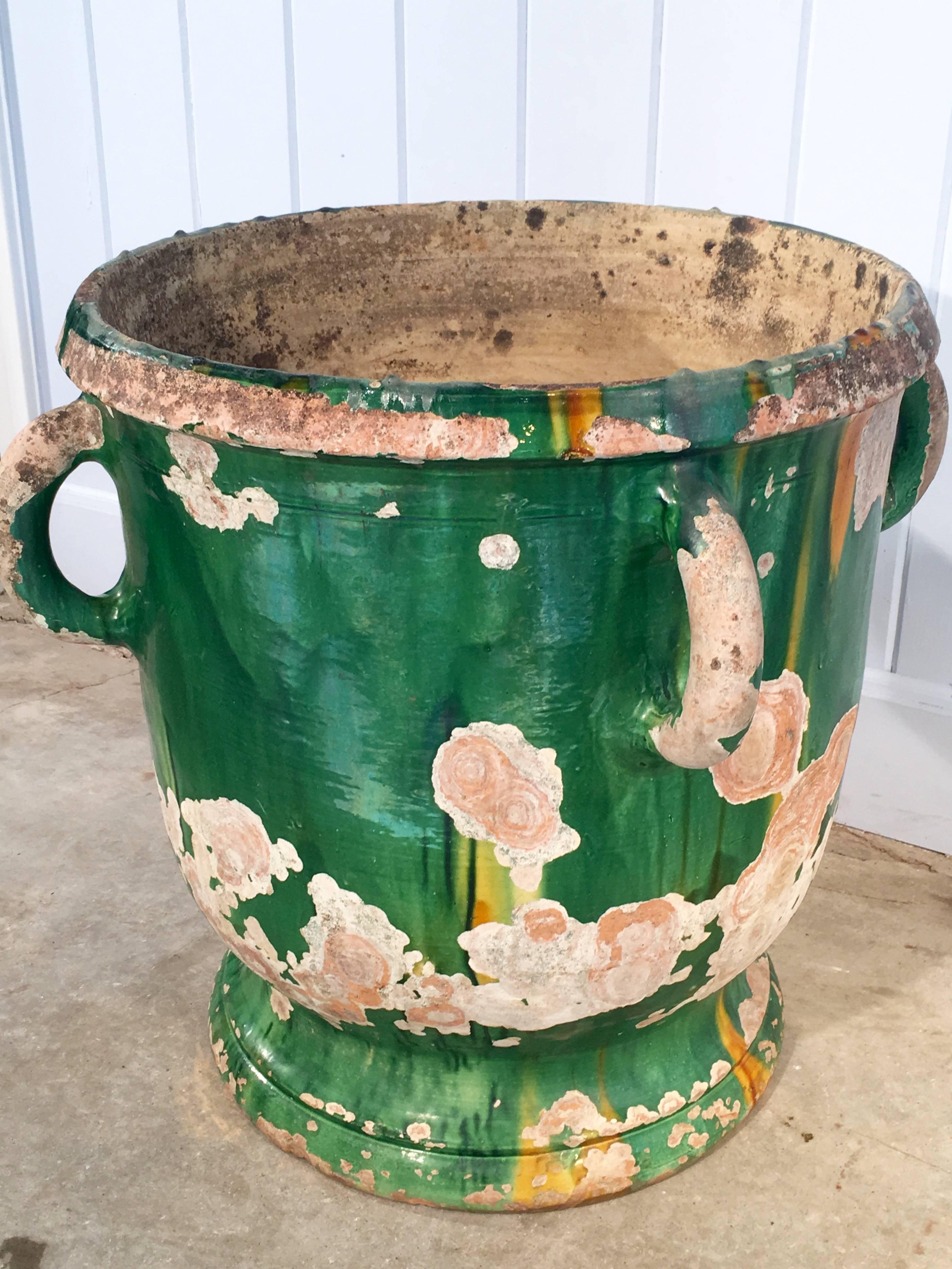 We love the intense green glaze of Castelnaudary planters, and this one is all the more beautiful for its chipped glazed surface that shows various hues of pink and white beneath the emerald green. Of medium size, this piece would be best grouped