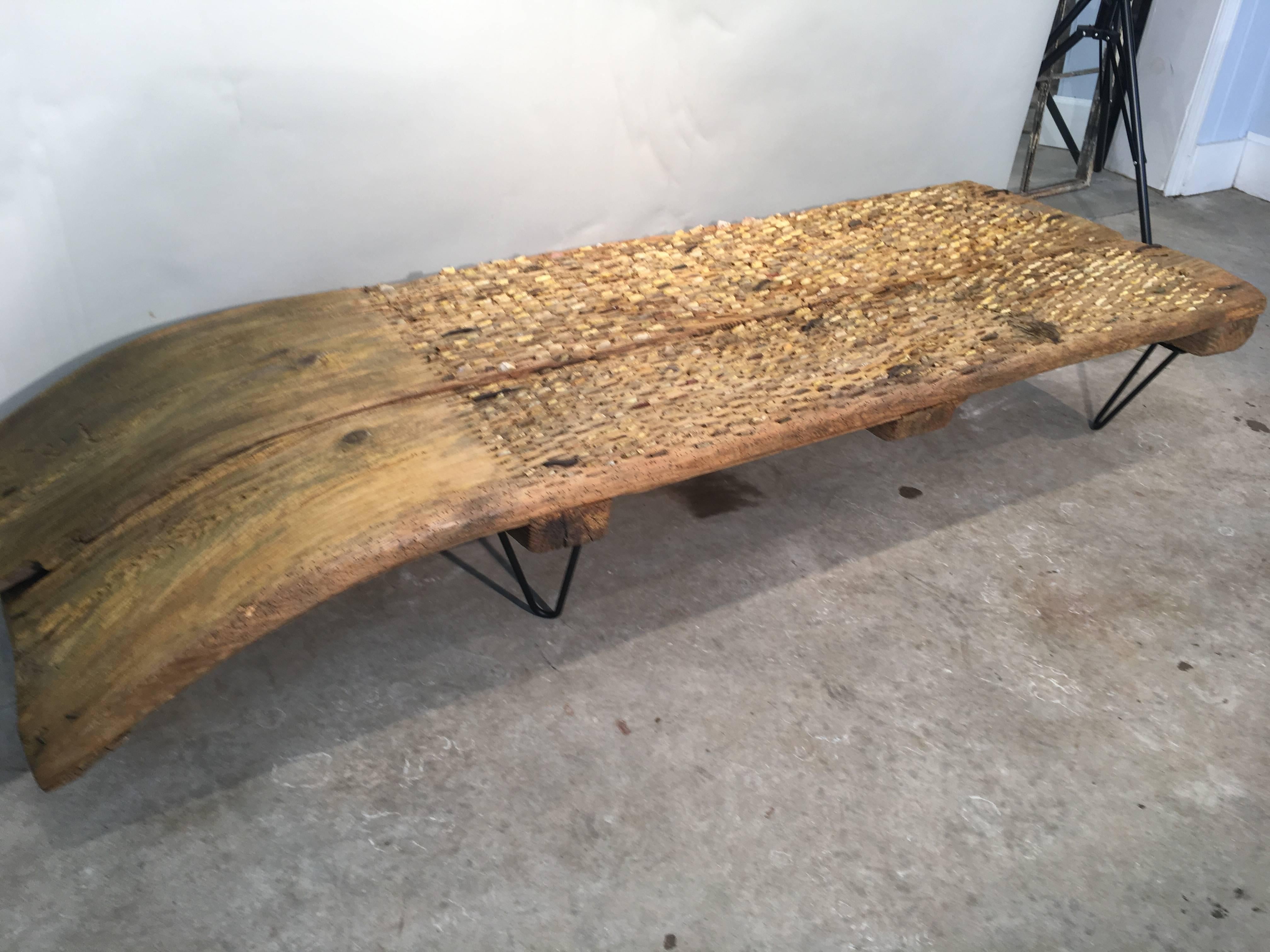 A tribulum is an ancient hand-made threshing board, inlaid with chips of flint or stone, that has been used since Roman times to separate grains from the chaff. 
We were fortunate enough to score two of these coffee tables, this one in a lovely