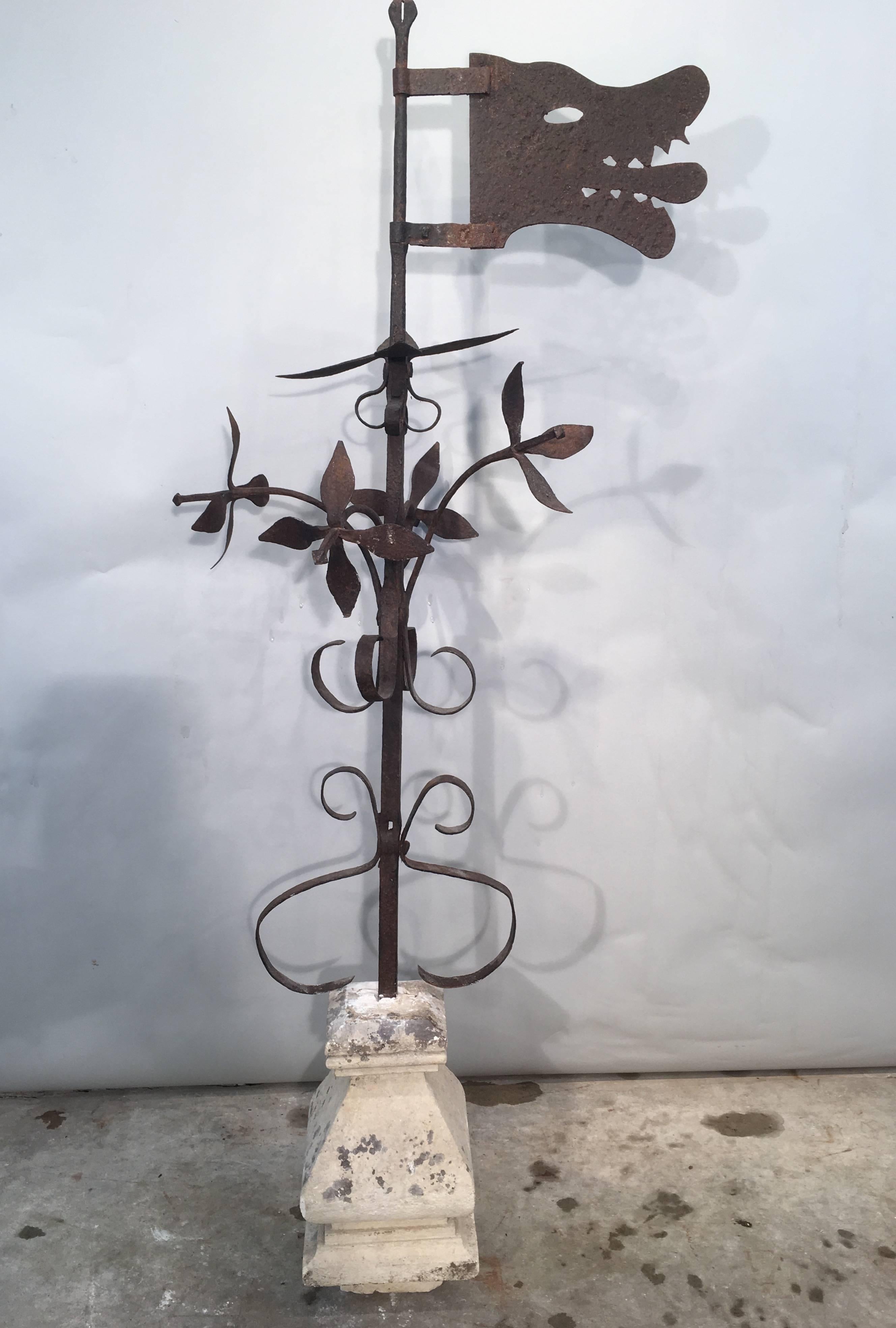 Now this is a striking piece one doesn't find every day! It features a swivelling 18th century hand-wrought iron wolf's head weathervane without directionals and a stem decorated with a profusion of riveted, hand-wrought iron flowers, mounted in a