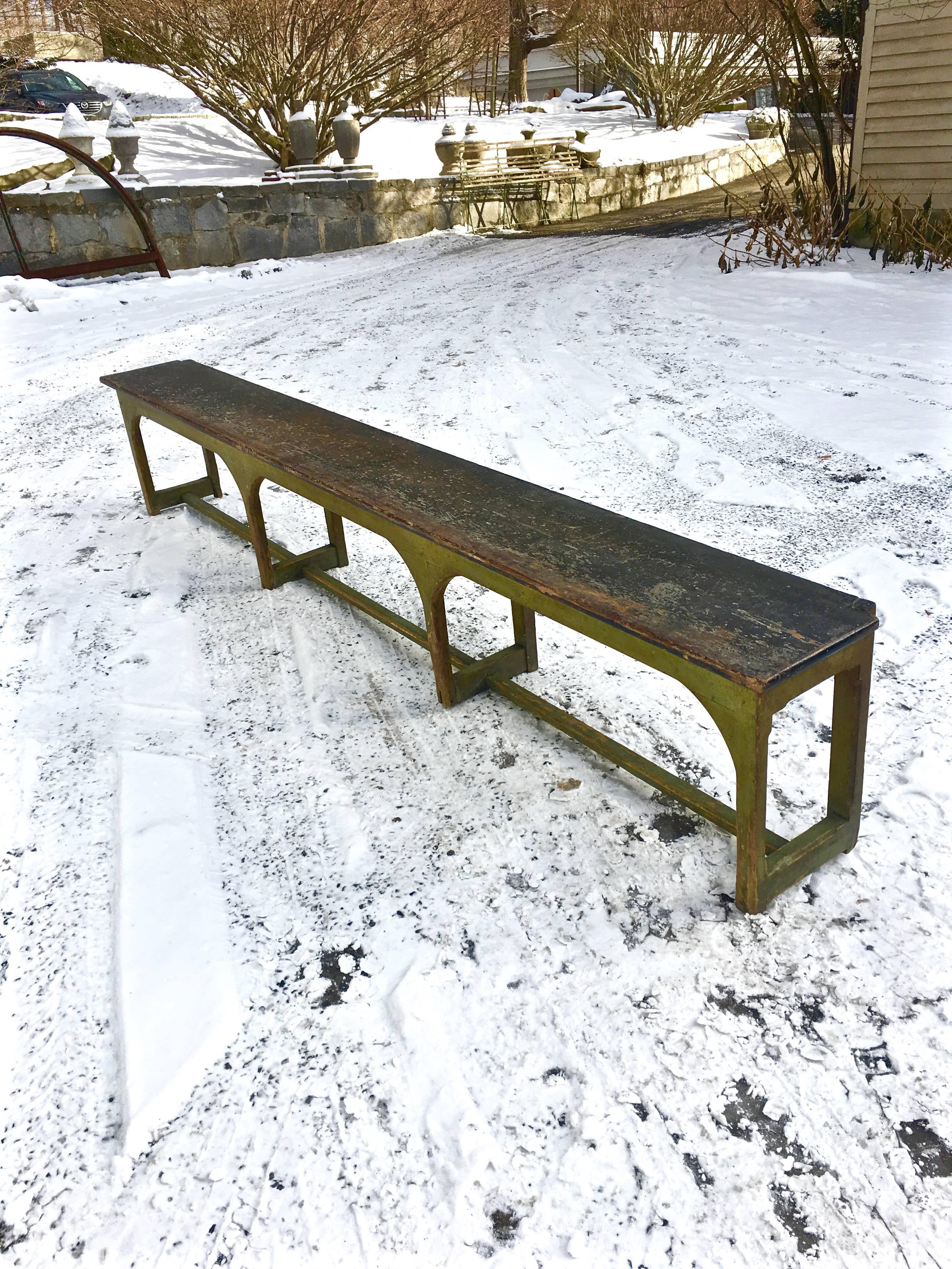 We couldn't help ourselves with this striking 10 foot long bistro bench, fresh from an old deconstructed French restaurant, and in its original and worn dark olive-green paint. It is constructed of an oak seat with a pine or poplar base, and is