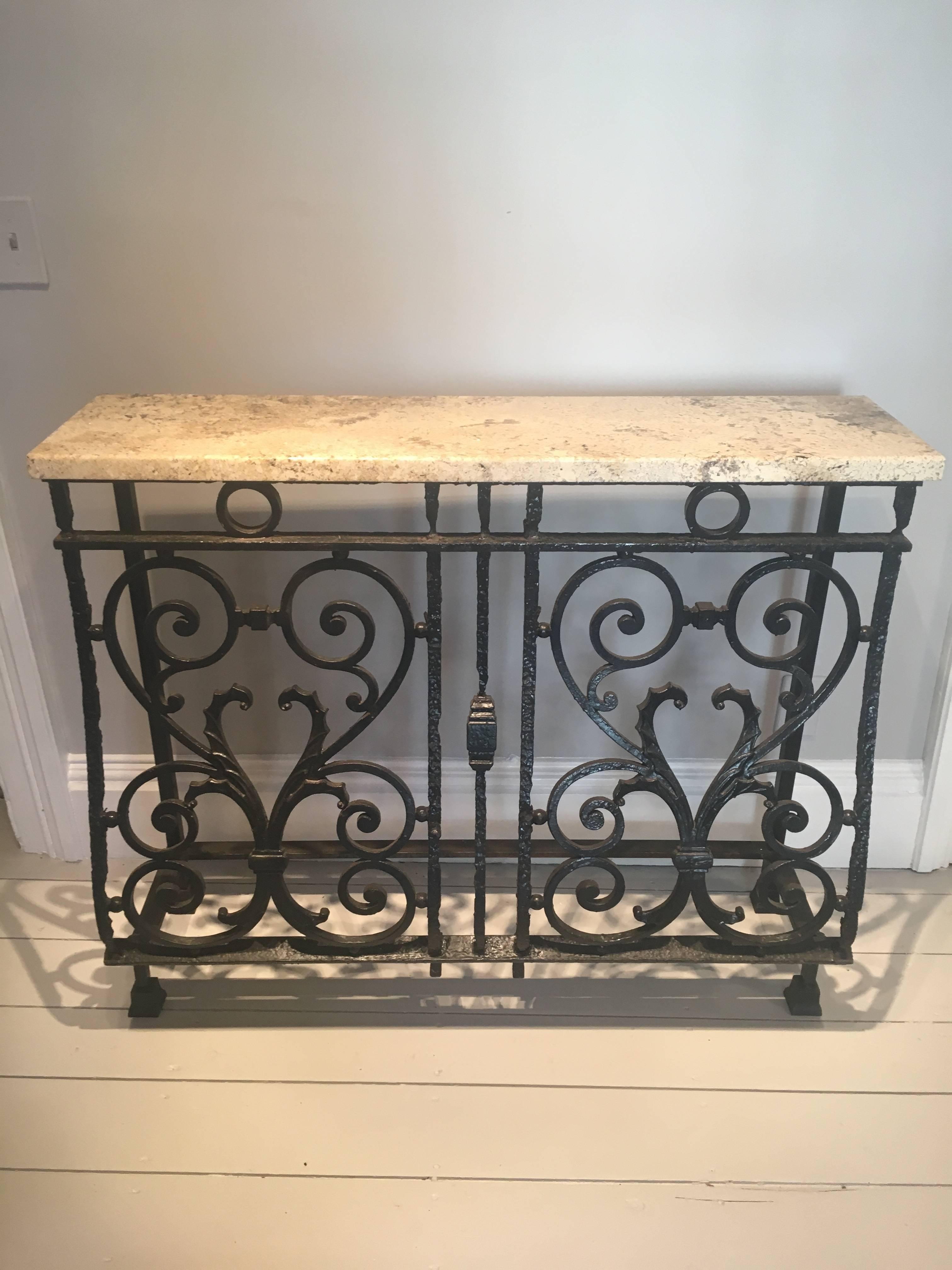 An unusual form and sensuous lines define this wonderfully-proportioned cast iron console table. Recently-fabricated from an antique balcony railing (from the Queen's Horse Guards' residence) and topped with a 1" thick speckled granite top