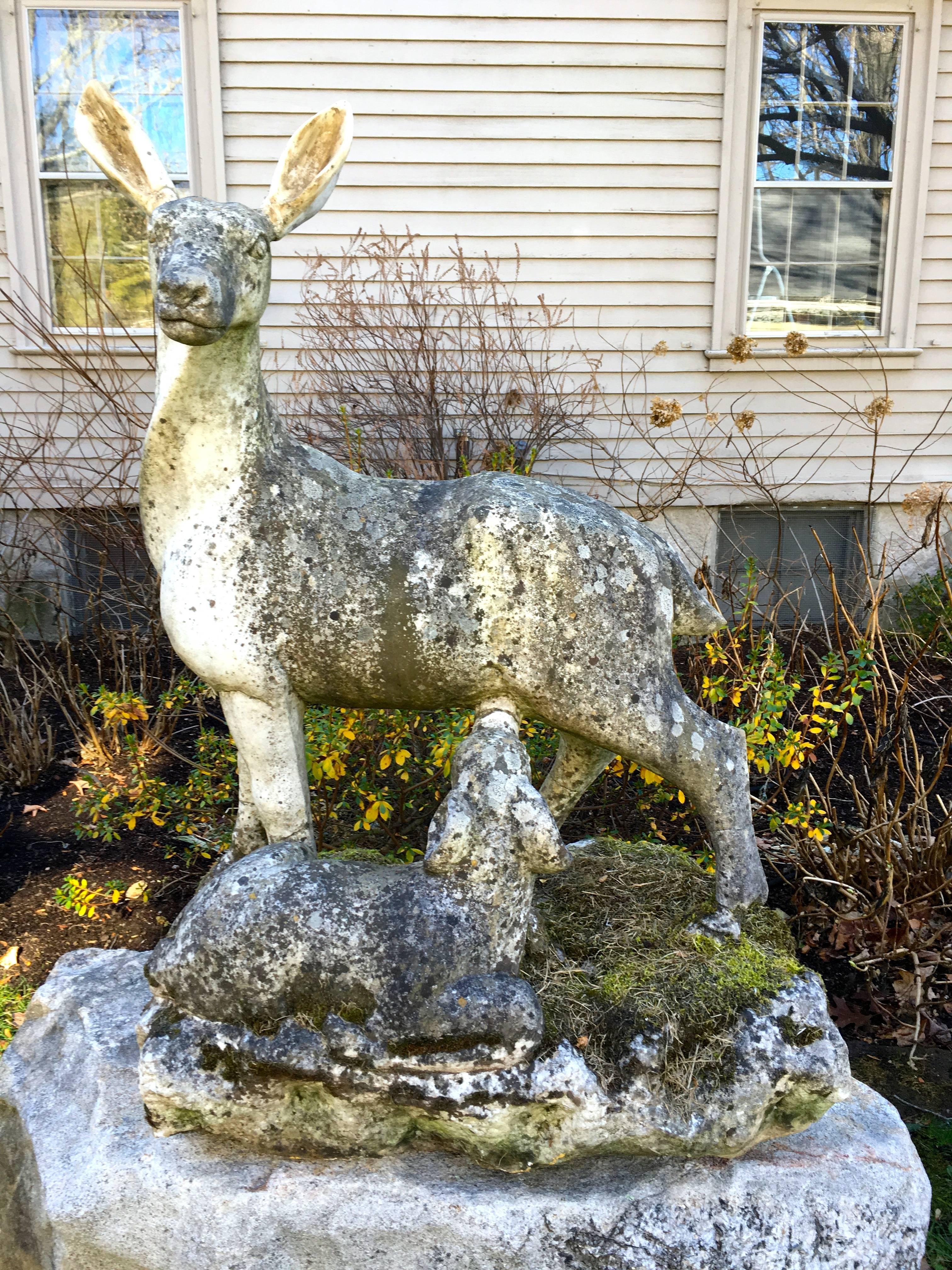 We were thrilled to have found this amazing marble statue in England, even though the ears on the doe have been replaced. With an incredible lichened and mossy surface, the piece depicts a nursing fawn and sits atop a boulder we sourced in