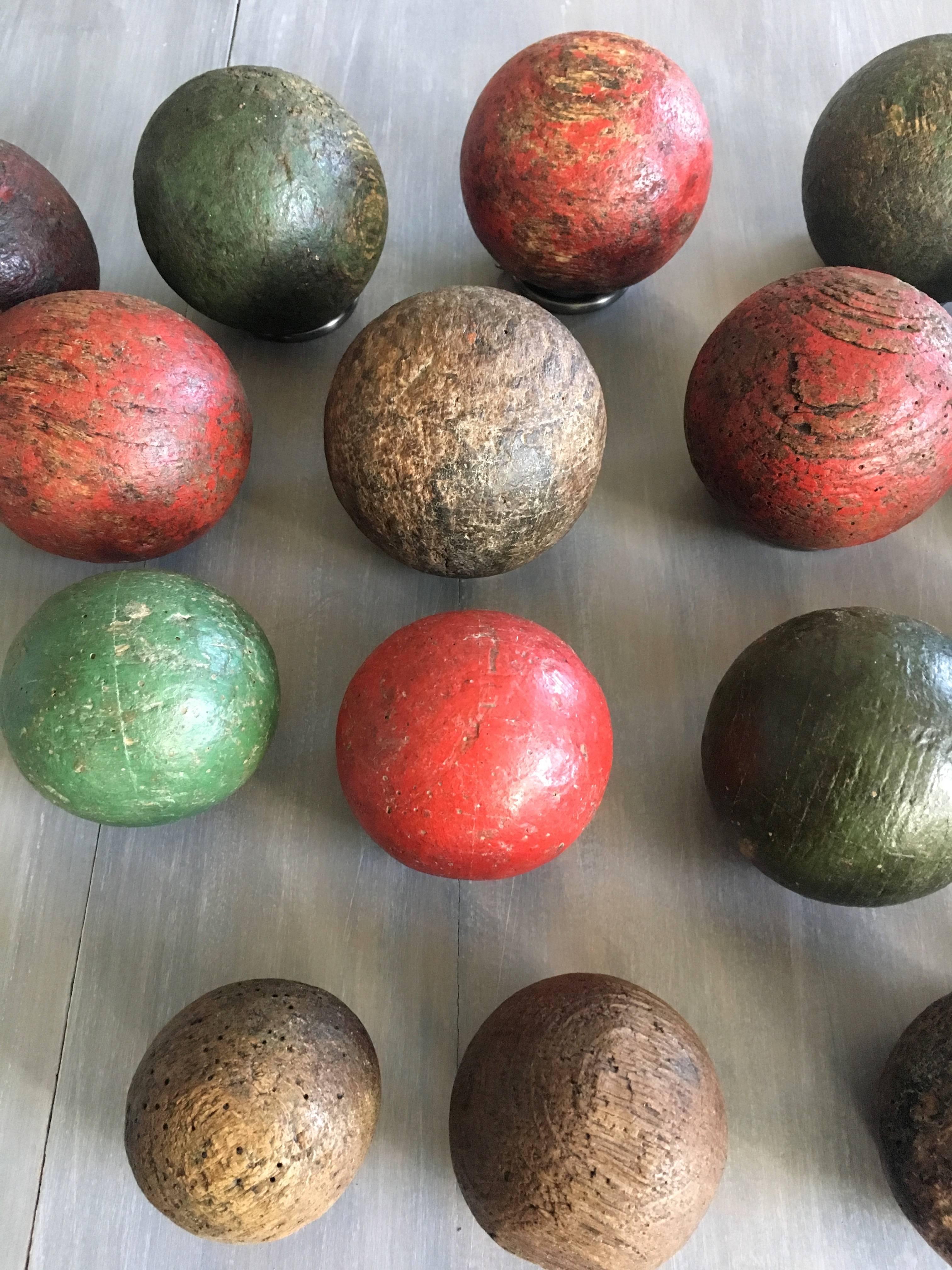 These are simply fabulous! A large set of hand-carved boules (most are of walnut) in their original painted surface, except for the four smallest boules, which were never painted. Used to play the game of 