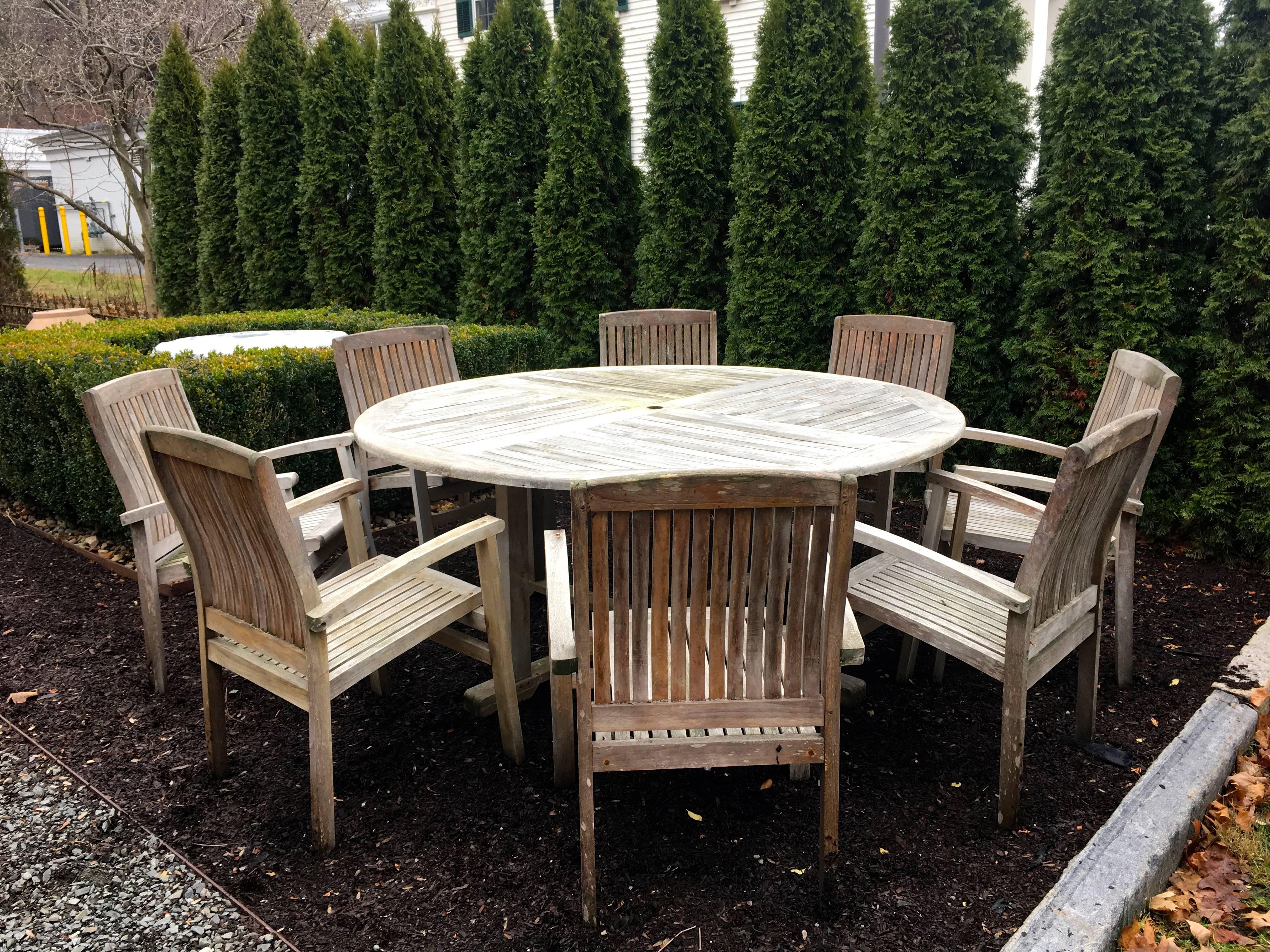 This nine-piece lightly silvered teak dining set is a perfect accompaniment for any garden or terrace. Stylish, comfortable and capable of working with just about any decor, the eight armchairs are commodious, very solid and invite you to linger