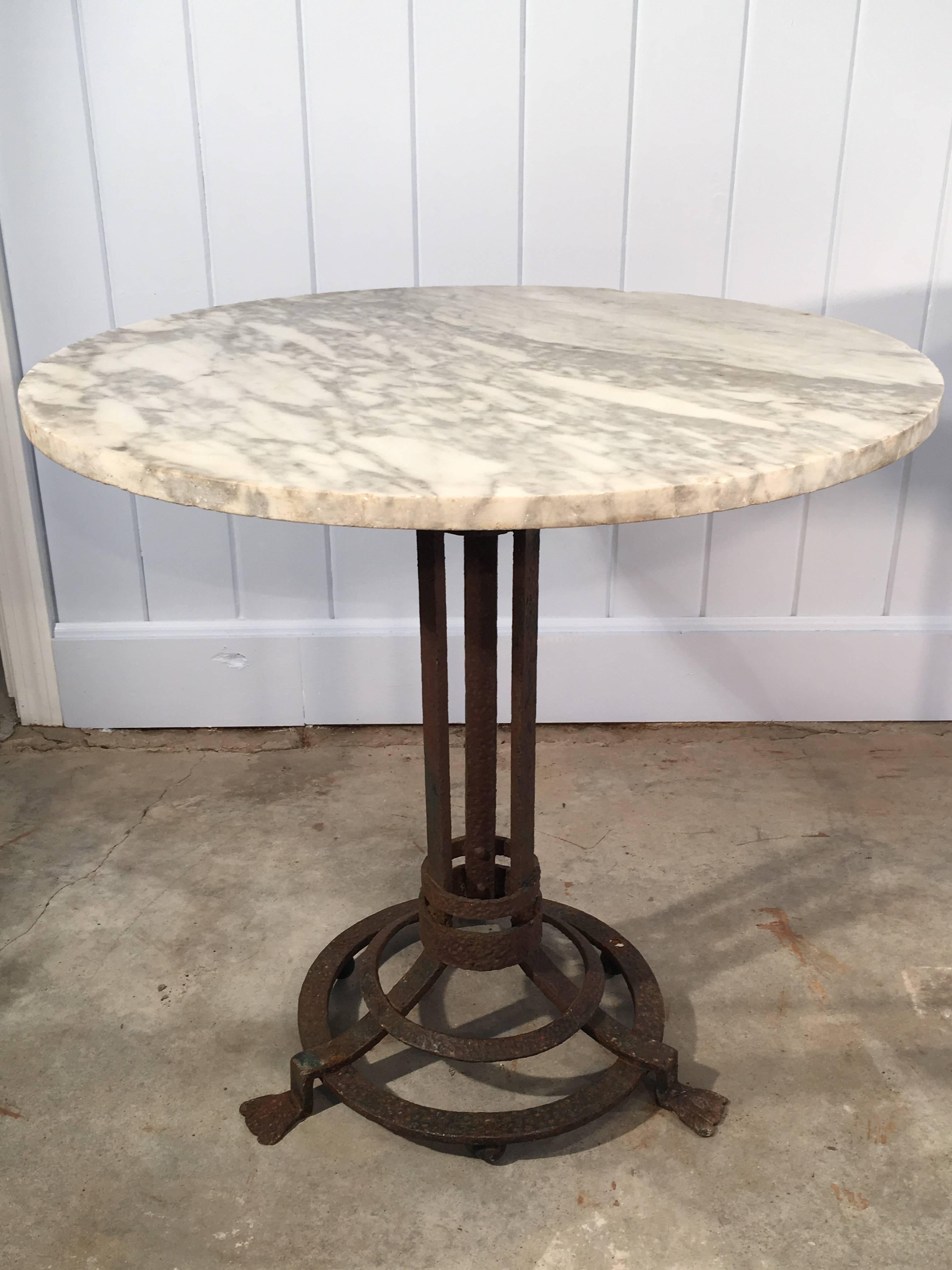 This pair of mid-19th century hand-wrought gueridon bases features a wonderful rusty patina and splay feet which are quite unusual and very decorative. We have topped them with rounds of 3/4" thick late 19th century English marble (white with