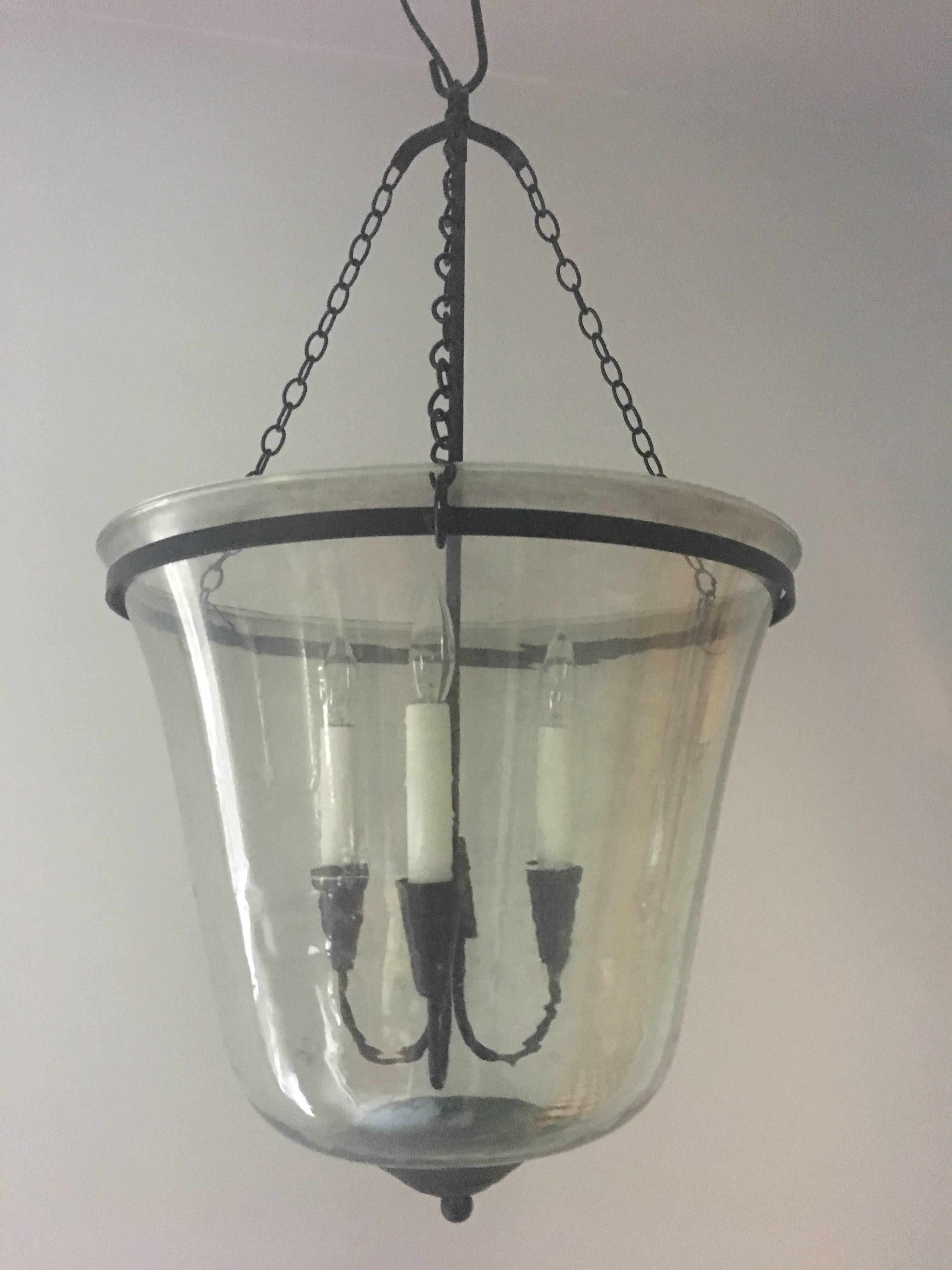 We've taken antique handblown green glass garden cloches (this one is a bell cloche) and transformed them into wonderful lighting fixtures. Each has a three-candle handcrafted wrought iron lighting cluster (total 225 w), custom ring holder, triple
