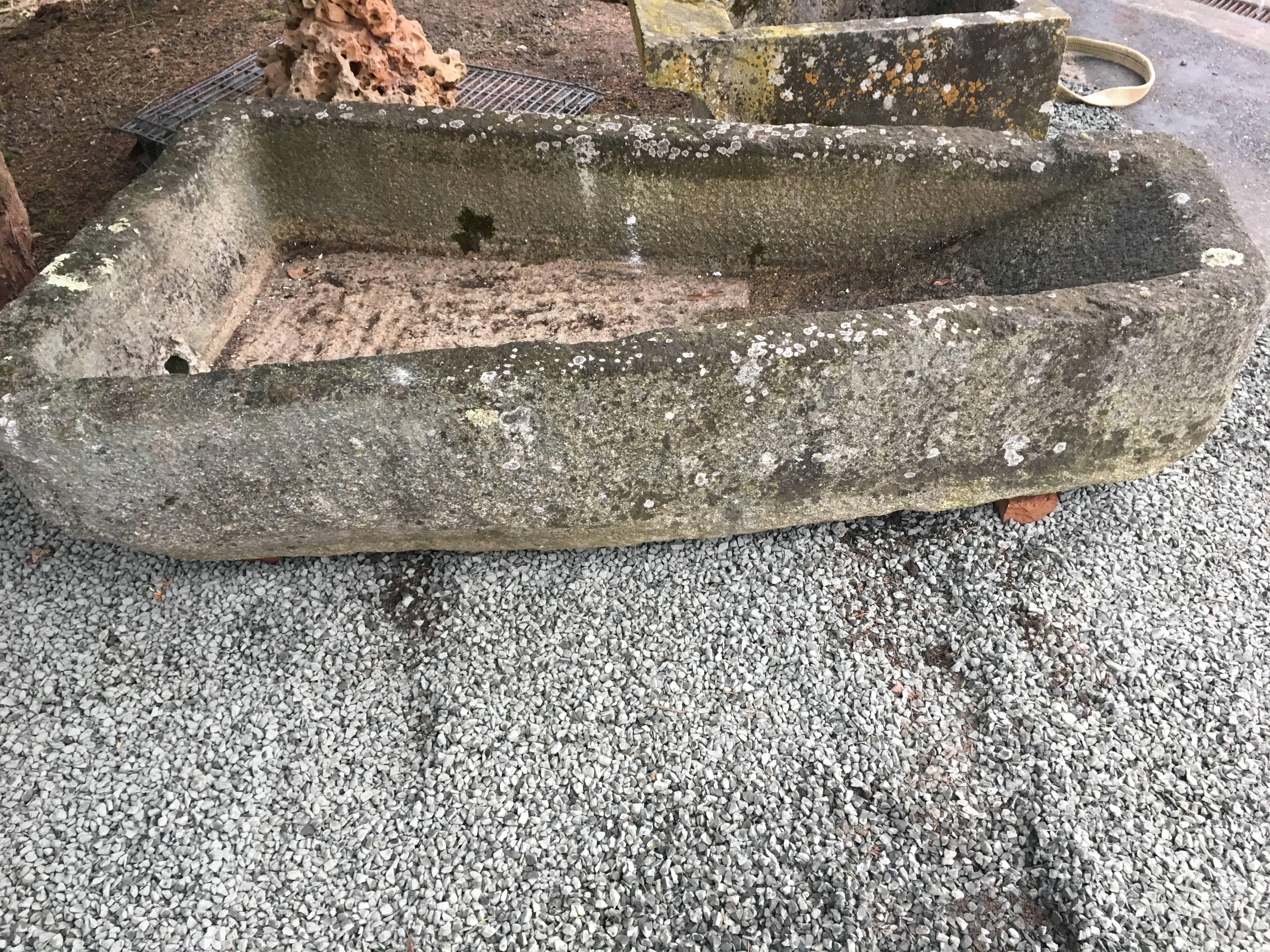 This rare and unusual keystone-shaped granite lavoir is from Sathe, France and dates to the 15th century. In amazing weathered condition, it has a contemporary feel because of its shape and color and would make an stunning focal point in your garden