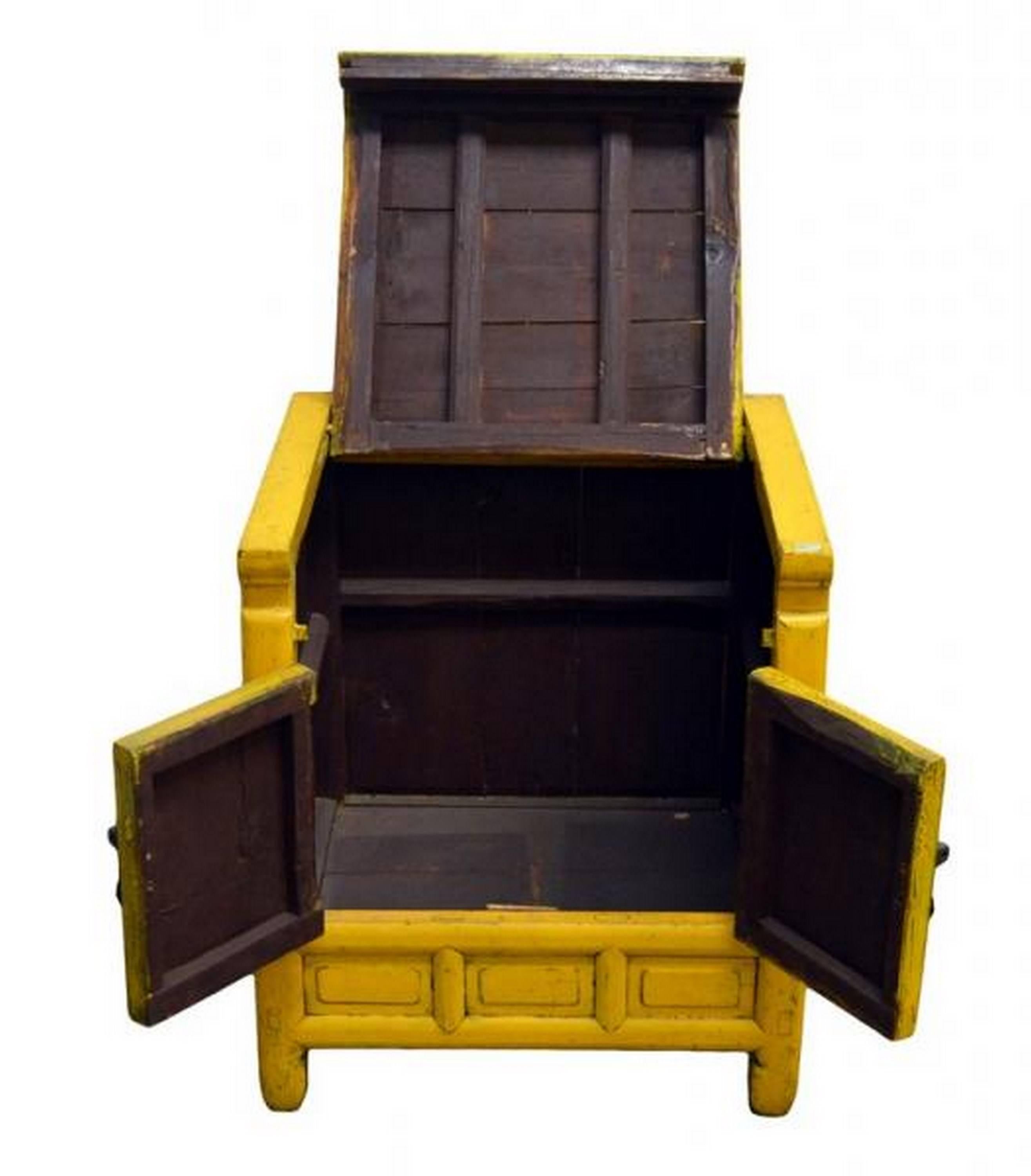 A 19th century Chinese side cabinet with yellow lacquered wood outside and black interior.  This cabinet adopts a cubic form standing on four legs that run from top to bottom.  On the front, the bottom displays three frame patterns below two carved