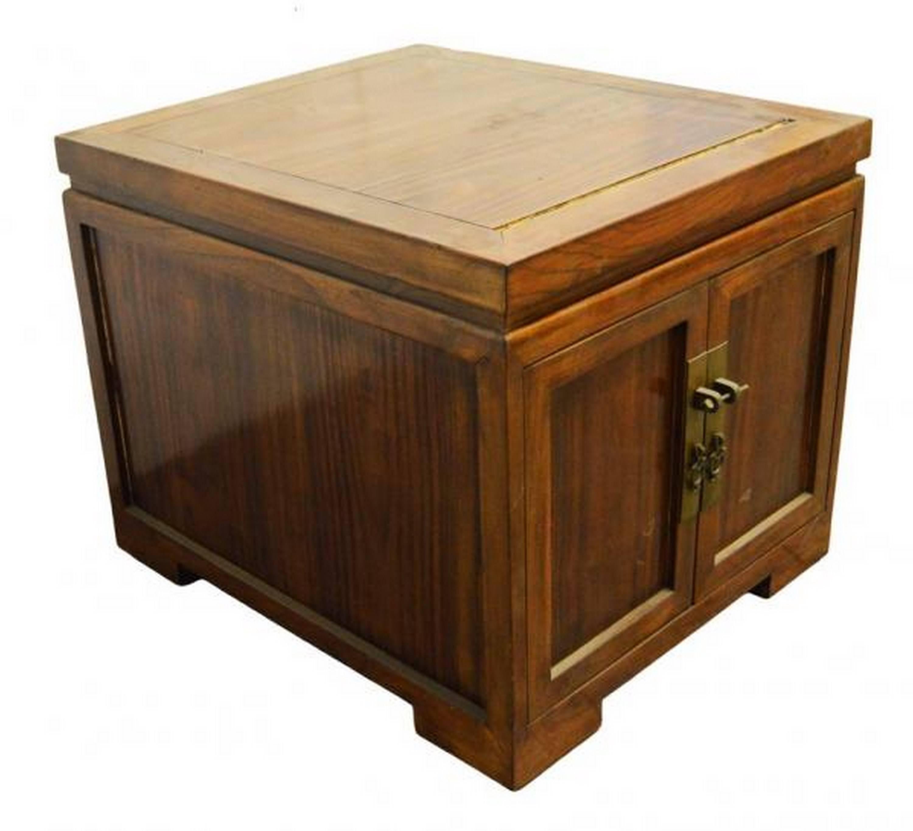 A brown lacquered Chinese bedside cabinet with traditional brass hardware and doors from the the early 20th century. This bedside cabinet features two doors that open via simple brass ring pulls and lock via a traditional brass lockset. The doors