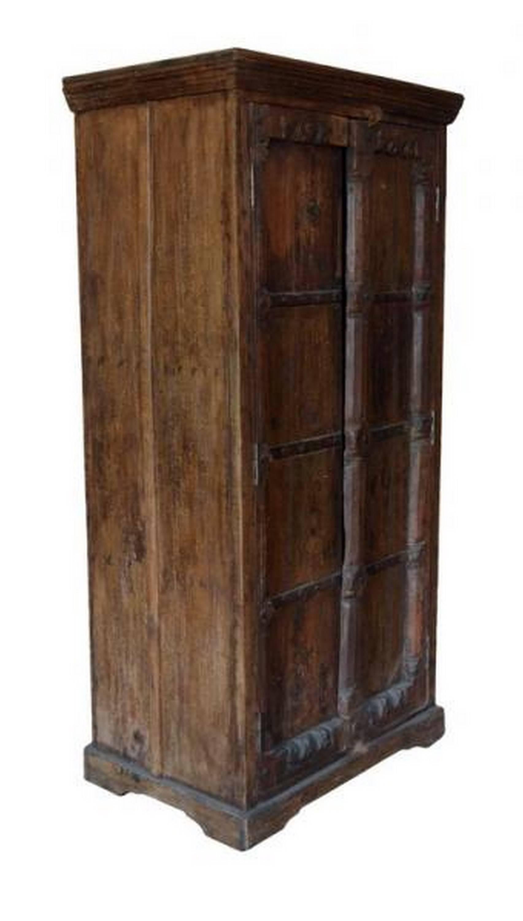 This handsome 20th century Indian wooden armoire features two doors opening to reveal three inner shelves. Its hand-carved doors display delicate Indian patterns, such as stylized flowers on the crosstie. The panels are fixed with metal hardware and