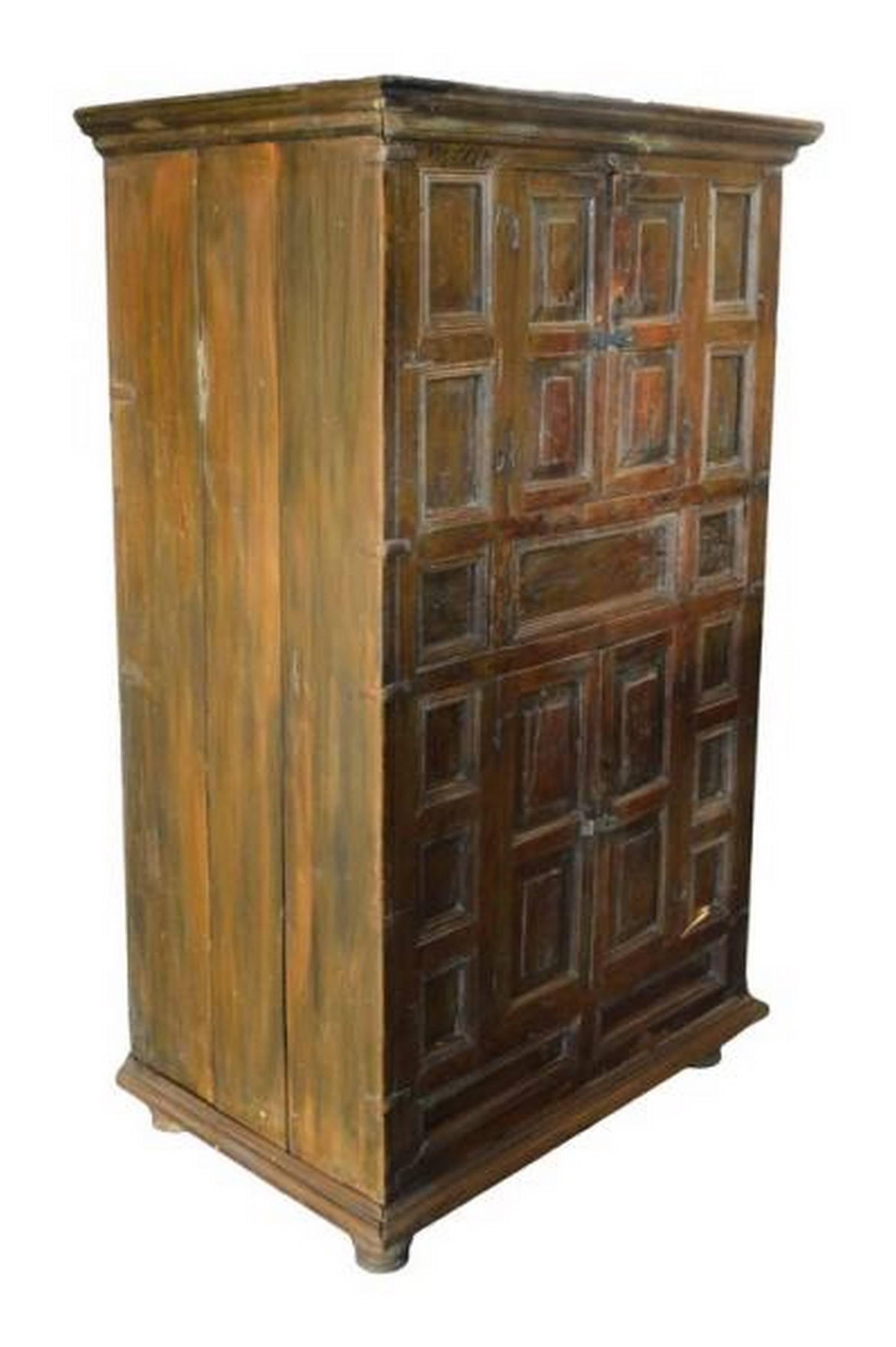 A mid-19th century rustic wooden cabinet with five hand carved doors made in India. This tall cabinet adopts an overall rectangular shape while its front façade is decorated with numerous rectangular details. The cabinet features one upper and one