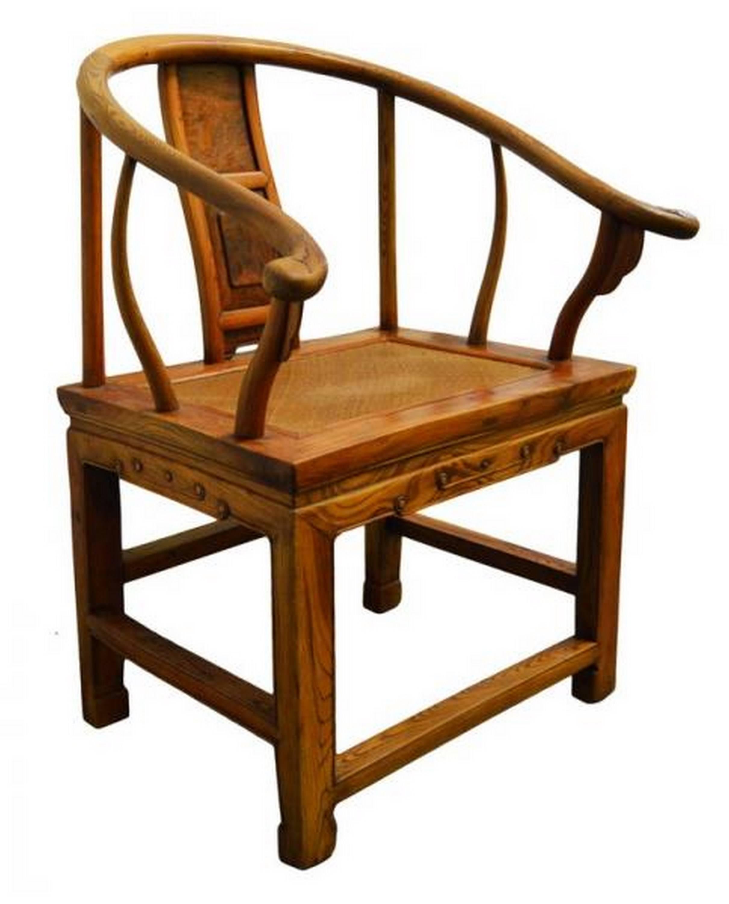 This Chinese 19th century chair with horseshoe back features a rattan seat and is covered with a light brown lacquer. The chair features a refined square base with carved scroll details on the sides, supporting a rattan seat. The back adopts a