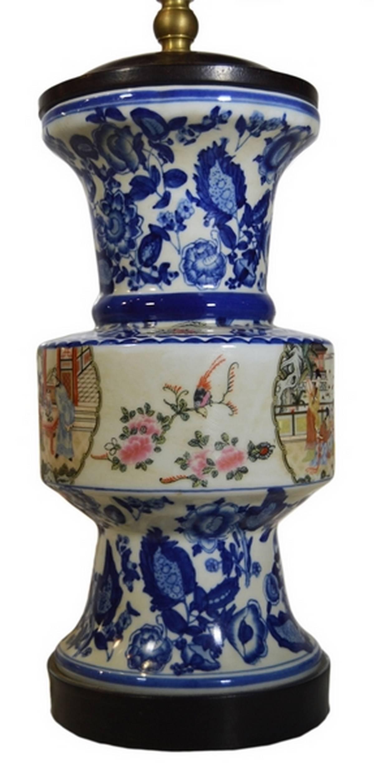A Chinese 1970s vintage porcelain lamp with hand-painted characters. This tall lamp displays three sections. The middle section is cylindrical with a hand-painted Chinese palace scene depicting an emperor among his courtesans and women with fans.