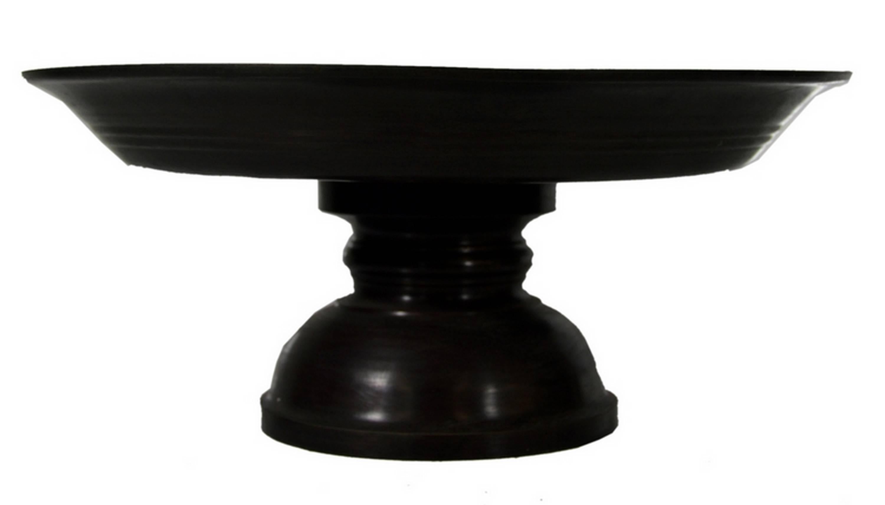A cake stand made of bronze in a refined cylindrical shape from the late 20th century. This cake stand displays a flat cylindrical plate with a small edge angled upward. This top rests on an hollow baluster leg with a large bottom. This refined cake