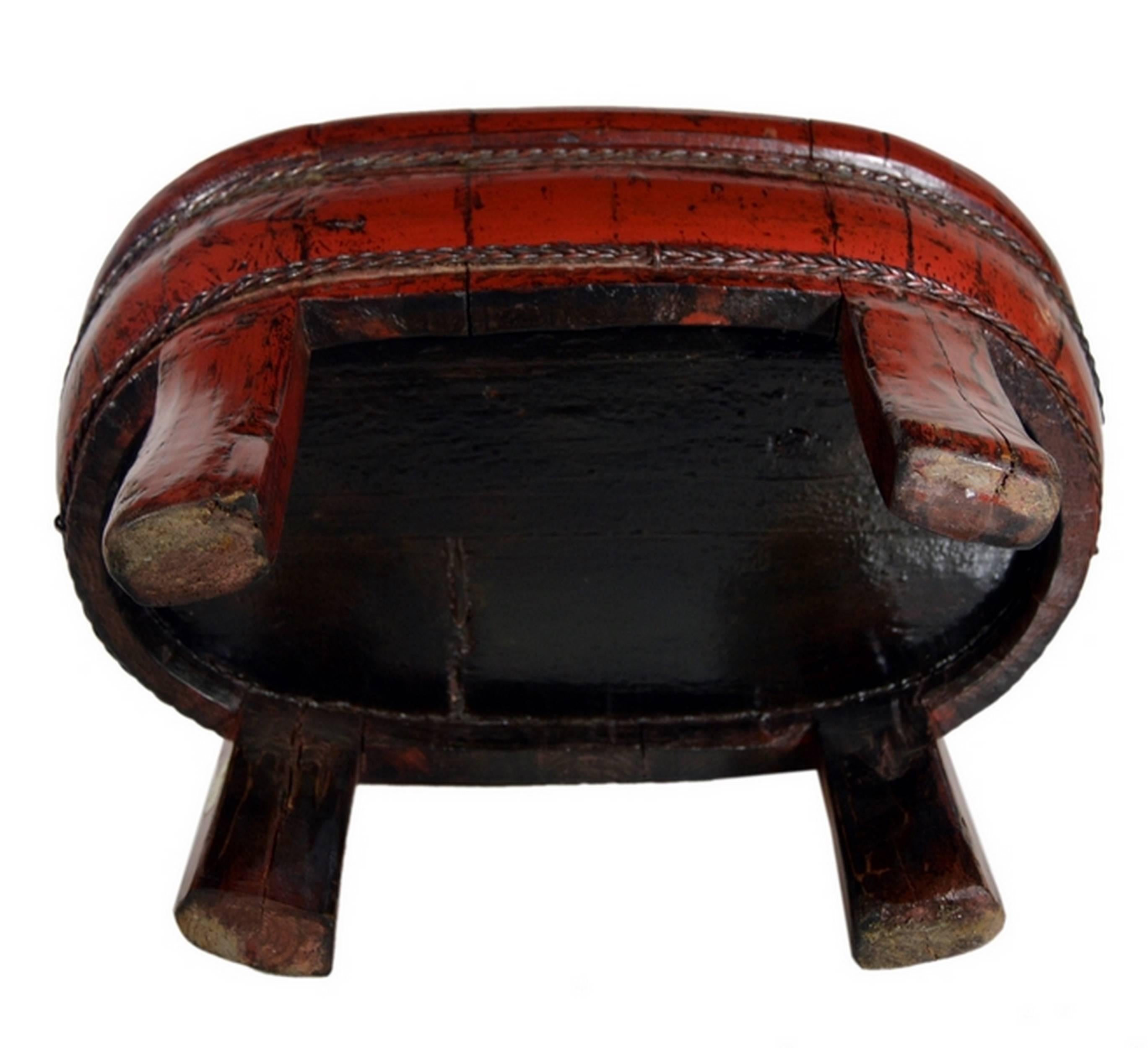 A Chinese 19th century legged bowl made with red lacquered wood and cords. This large oval bowl rests on four tall fine legs. Two cords adorn the belly and add faux support to the bowl. The bowl is largely made of red lacquered wood, except for the