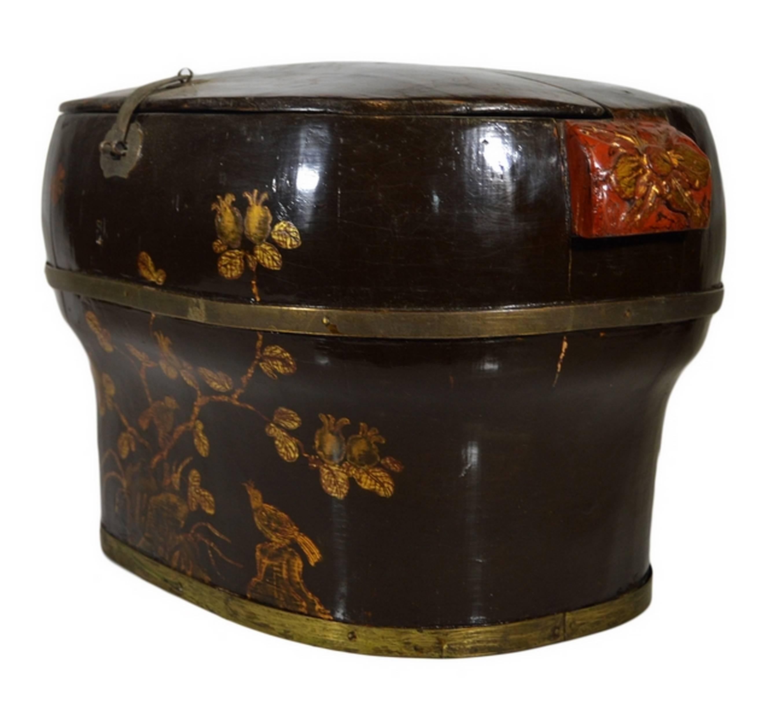 A beautifully hand-painted and lacquered 19th century Chinese wedding box with flowers showcasing an unusual round shape. This box is made of lacquered wood with metal hardware details such strip on the bottom and another separating the upper and