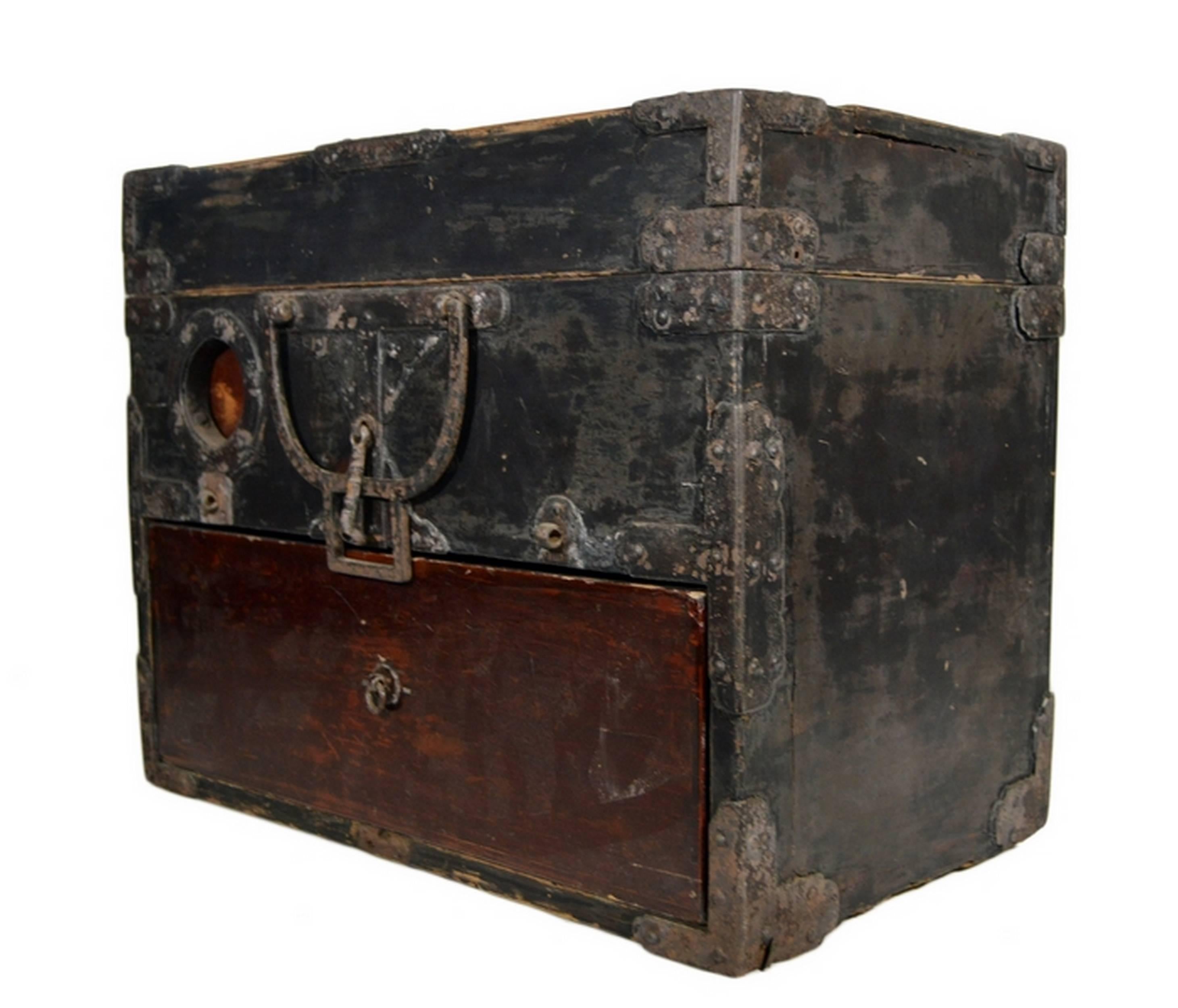 An antique handmade Chinese money box with metal hardware from the 19th century. This rectangular box is made of two-tone wood. The front displays a dark brown bottom drawer that opens via a simple metal ring pull.  Above sits a metal handle that