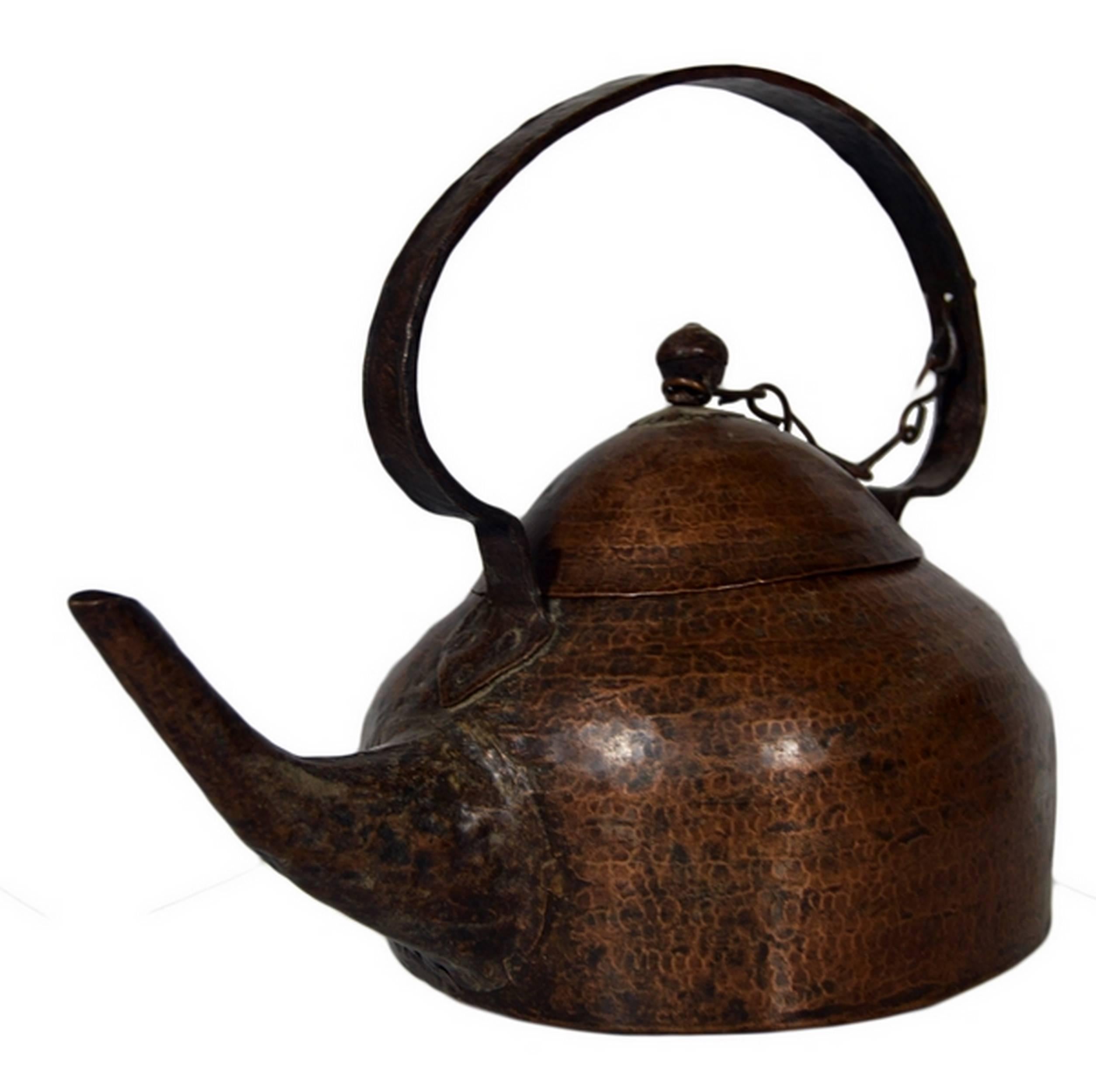A vintage 1930s teapot from India where it was hand-hammered on copper which displays time’s patina. This teapot adopts a pleasant pyramid shape with a long spout and a tall round riveted handle. The round handle of the conic lid is tied to the