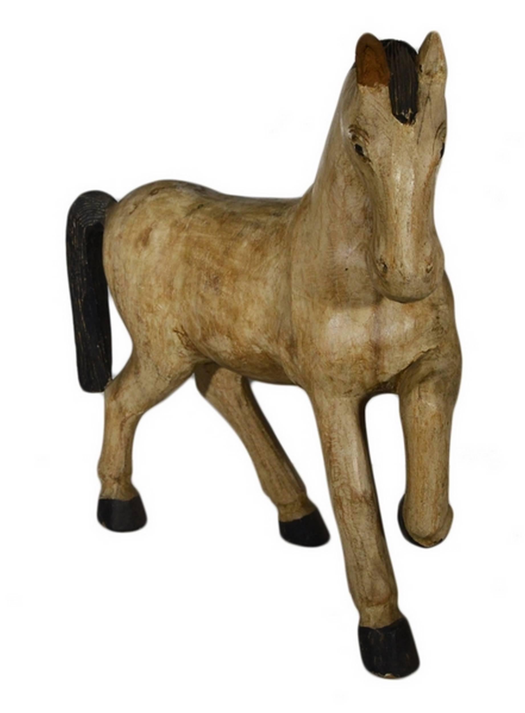 A vintage painted wooden horse from Indonesia, circa 1940s. This enjoyable horse adopts a dynamic and supple walking posture, with its left front leg raised. That this horse is hand-carved can be seen thanks to traces of strokes on its torso,