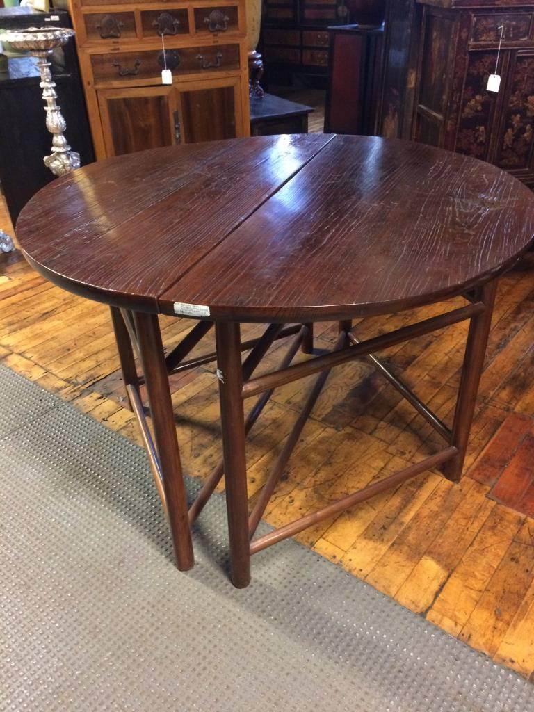 A pair of Chinese demilune tables from the end of the Qing dynasty. This Chinese 19th century pair of antique demilune tables was made with elmwood during the latter stages of the Qing dynasty (1644-1912). These tables display on their top a visible