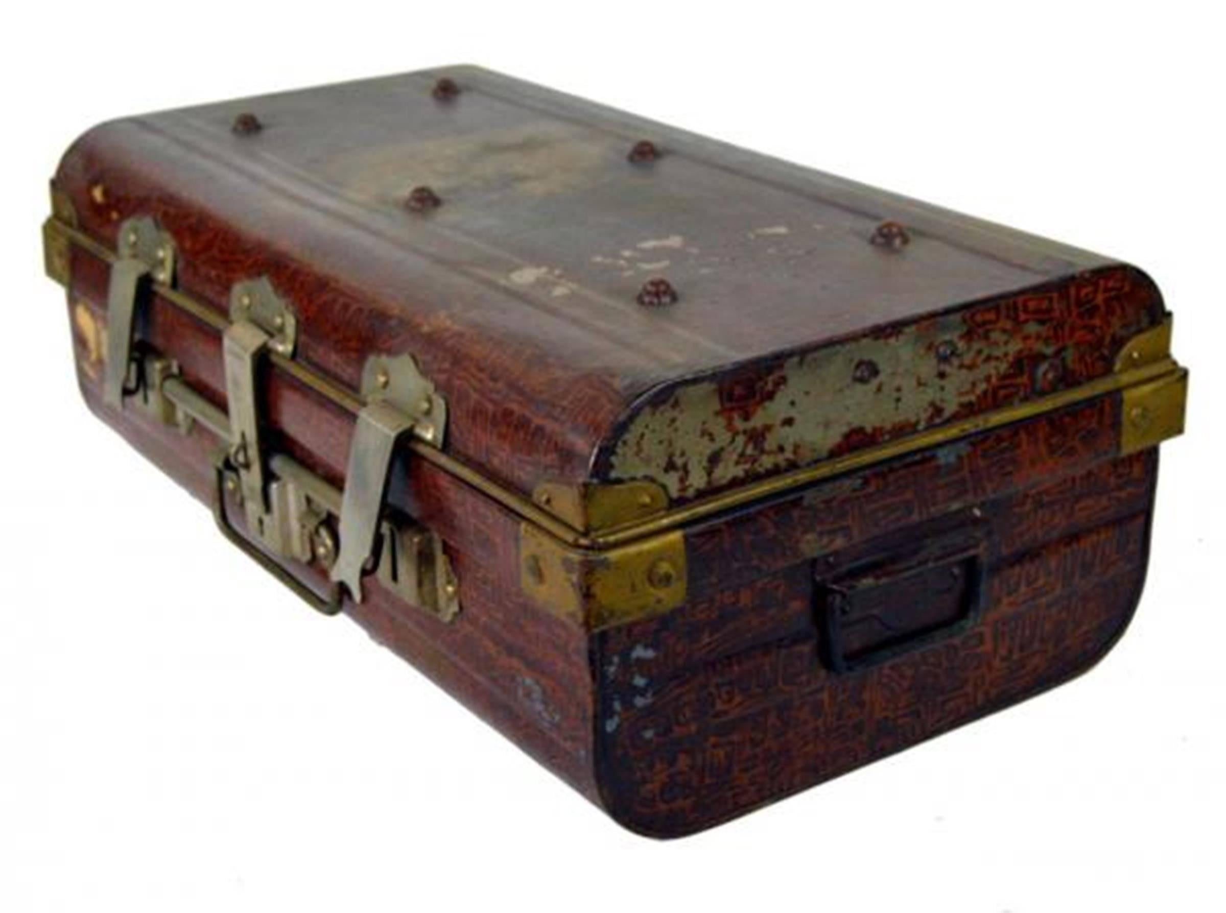 A 19th century locked metal trunk made for export by the British firm Wilkes & Son. This rectangular trunk was made in metal and painted like a red leather reproduction. Gilt hardware reinforces the corners while a three piece metal lockset secures