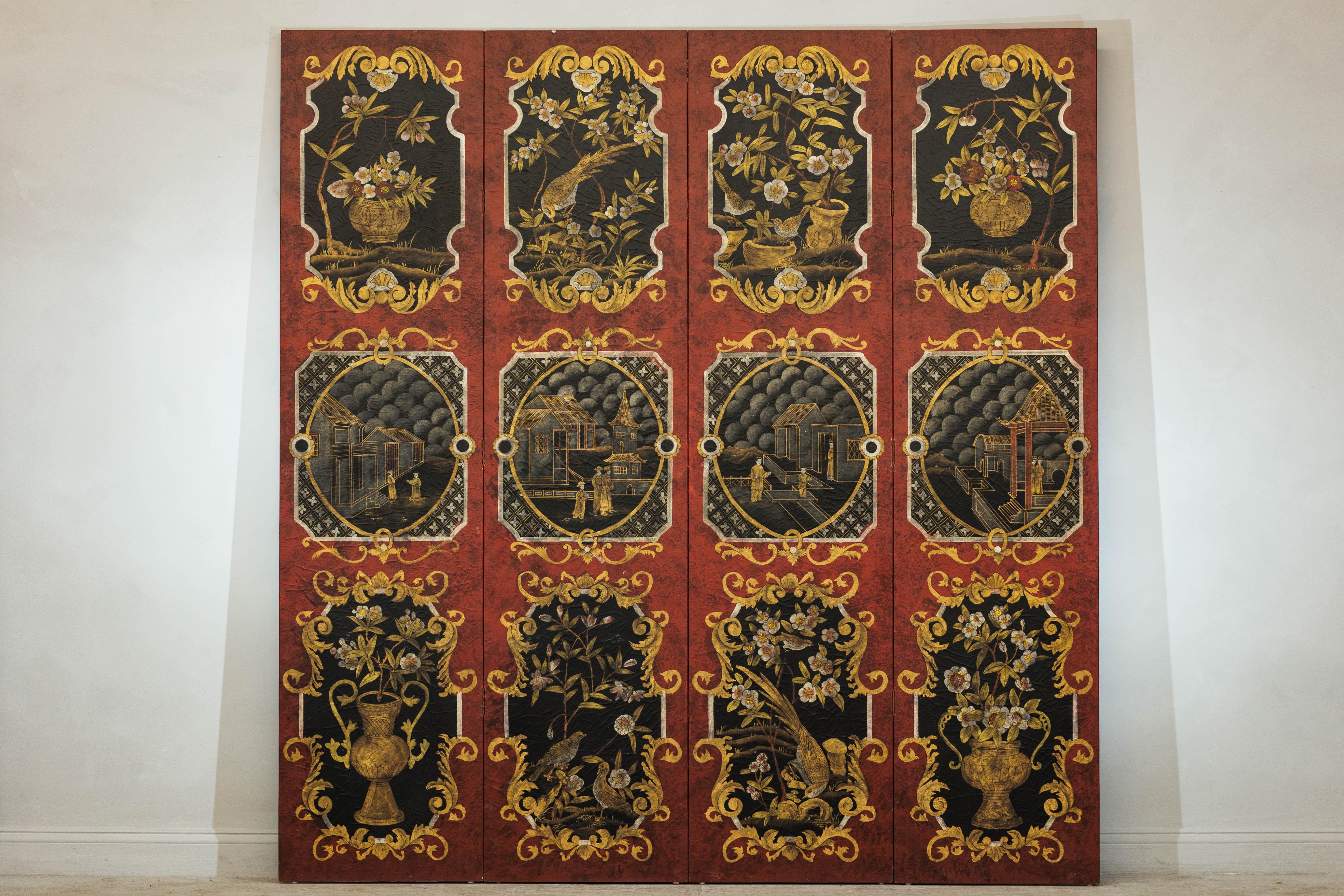 This richly detailed four-panel screen showcases a striking palette of cinnabar red and deep black, adorned with an array of finely painted chinoiserie motifs in gold, cream, and soft earthy tones. The piece is composed of twelve decorative