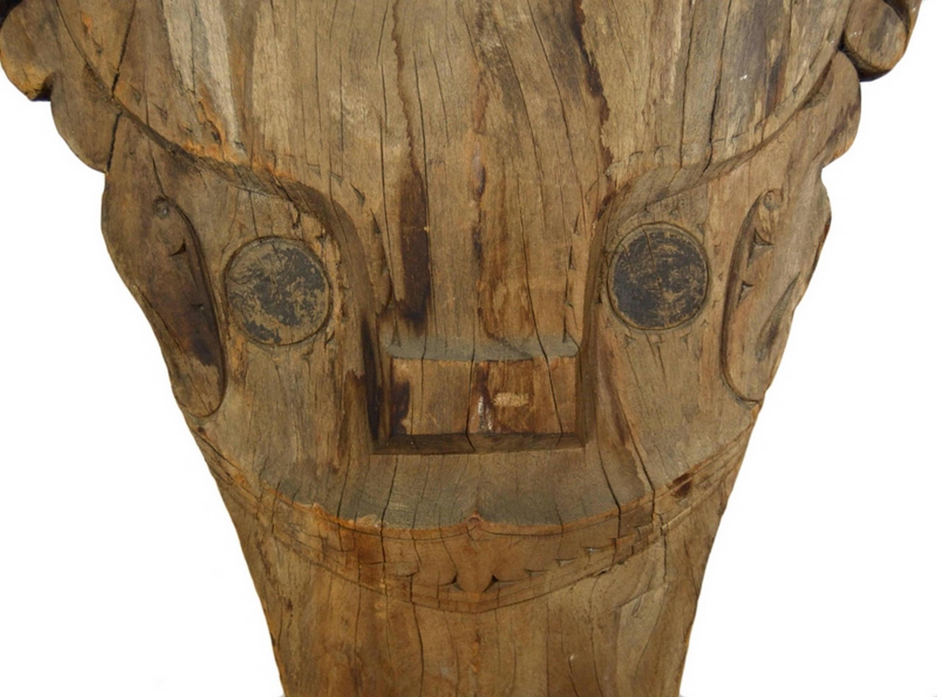 An antique Batak temple mask hand-carved of wood from the 20th century. This tall mask was hand-carved of wood in Sumatra, Indonesia. The mask adopts an abstract diamond shape with a central pattern evoking a standing woman surrounded by openwork