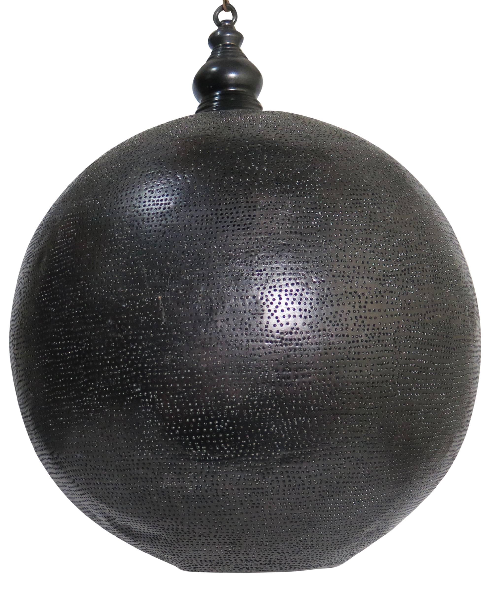 Metal pendant light with a blackened finish. Pierced holes throughout.