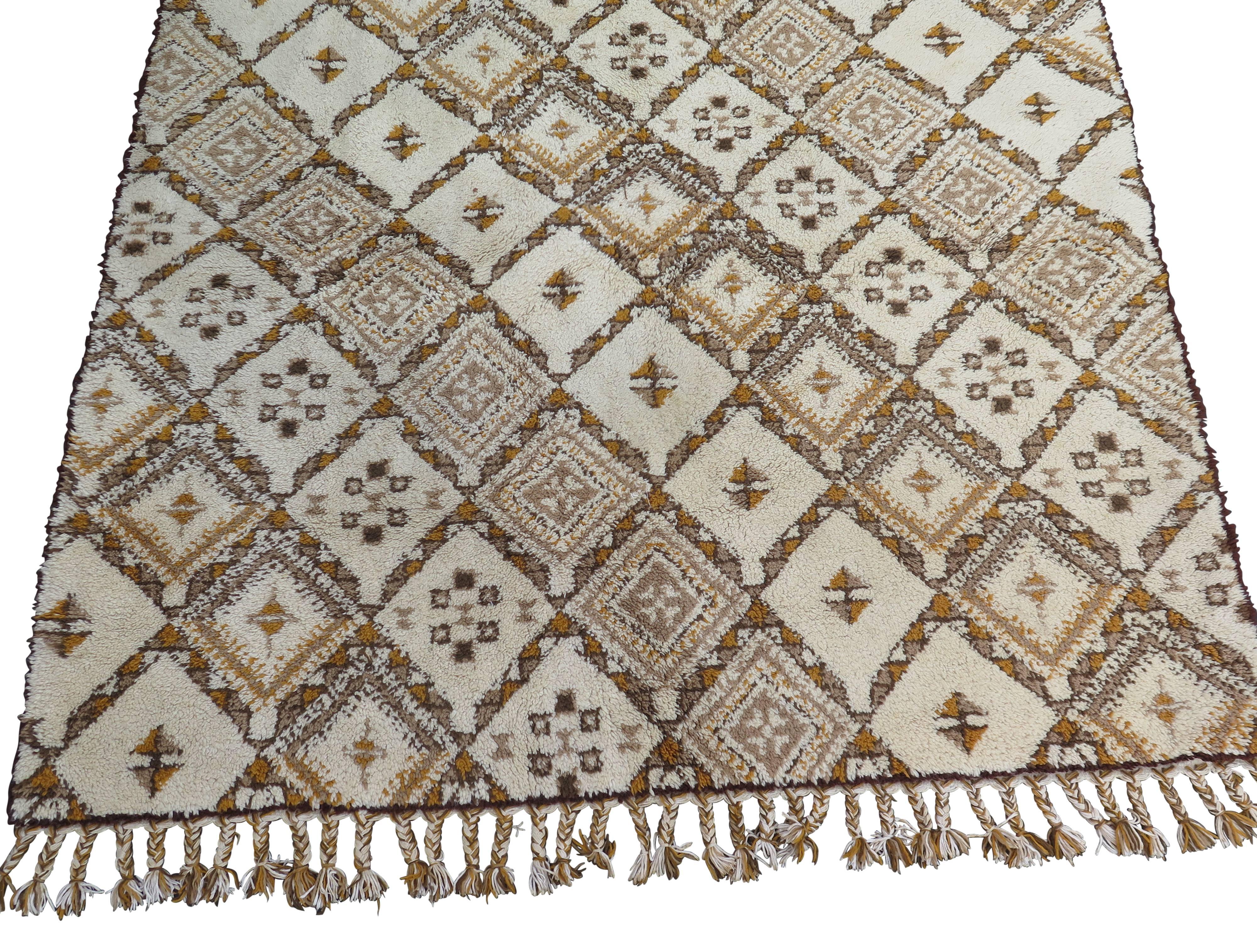 Beautiful nomadic rug, likely made in the 1940s-1950s. White with earth tone geometric patterns and beautiful braided tassels.