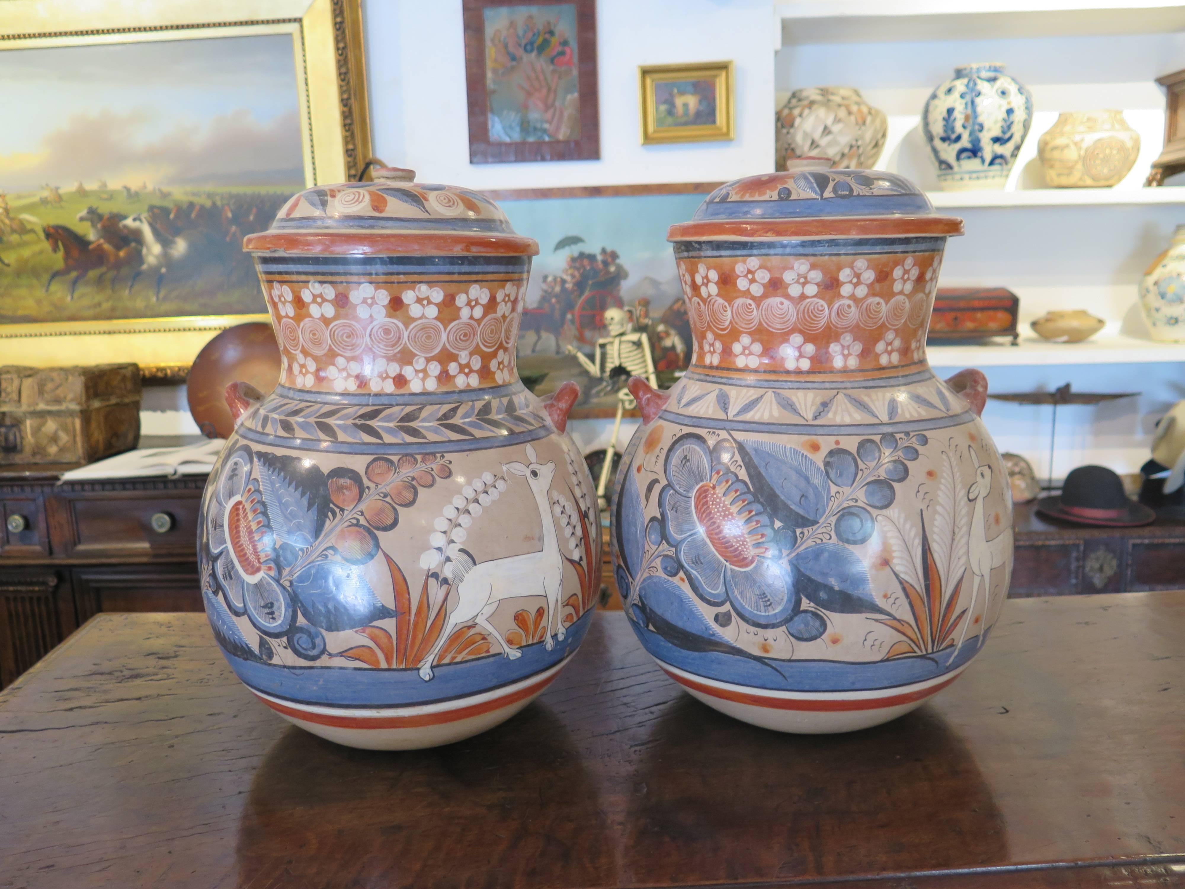 Nice looking pair of vintage Mexican Tonola jars with floral and animal designs.