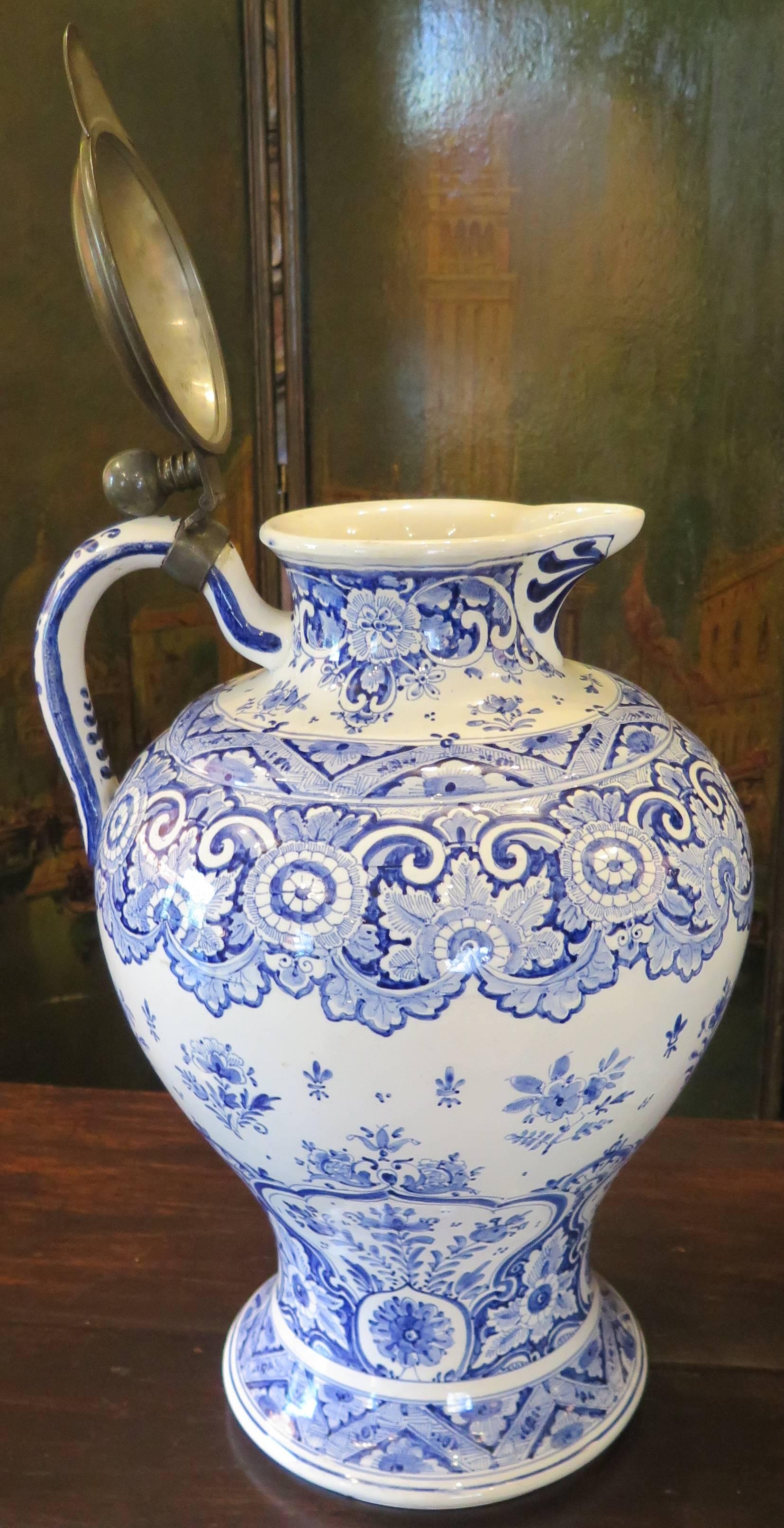 Nice pair of 19th century delft pitchers with bronze tops.