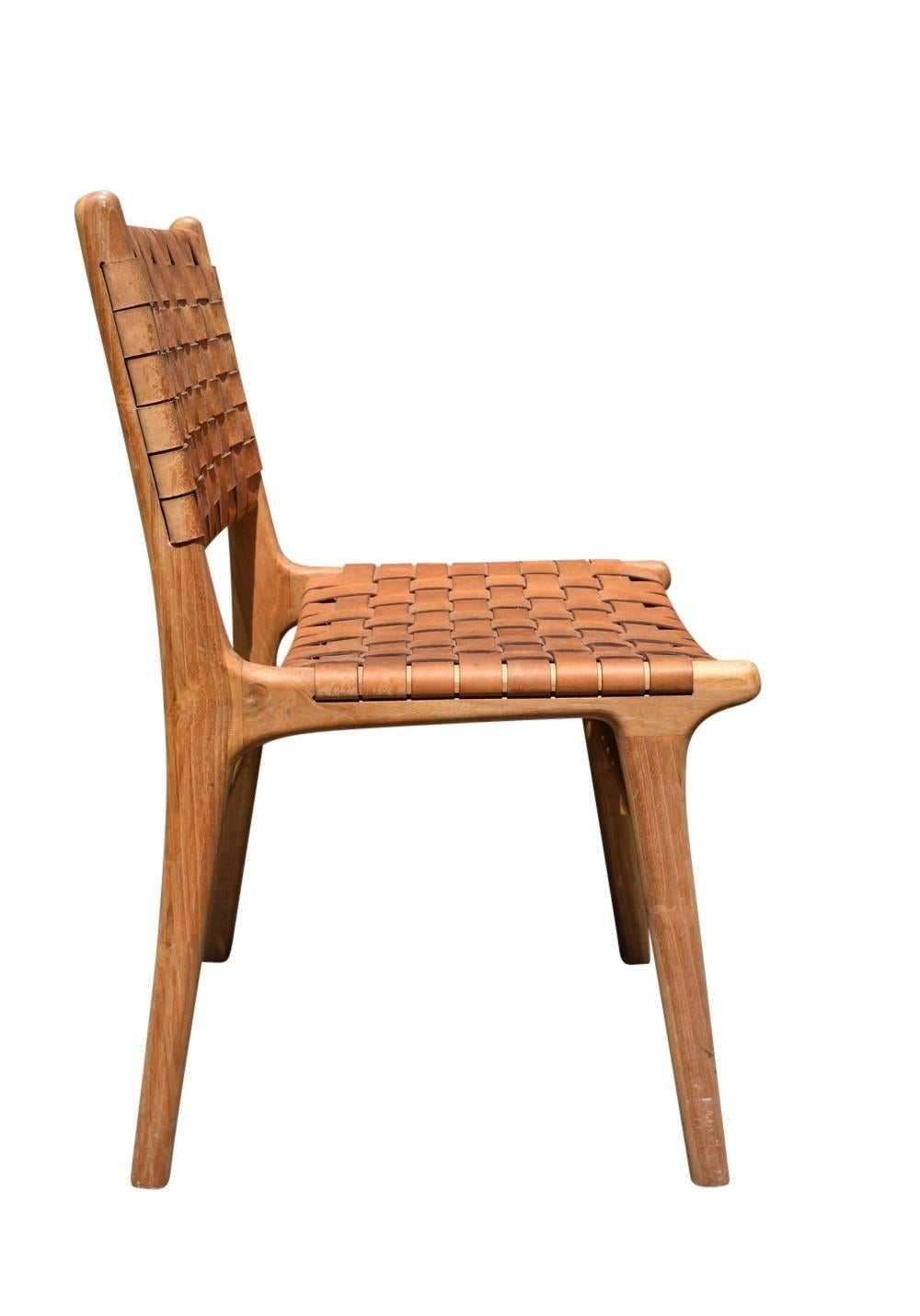 The "Flora" dining chair features natural leather strapping with brass finish tack. Shown with natural finish. These chairs are very comfortable and can be done in a number of different leather colors and finishes. 14-16 week lead time.