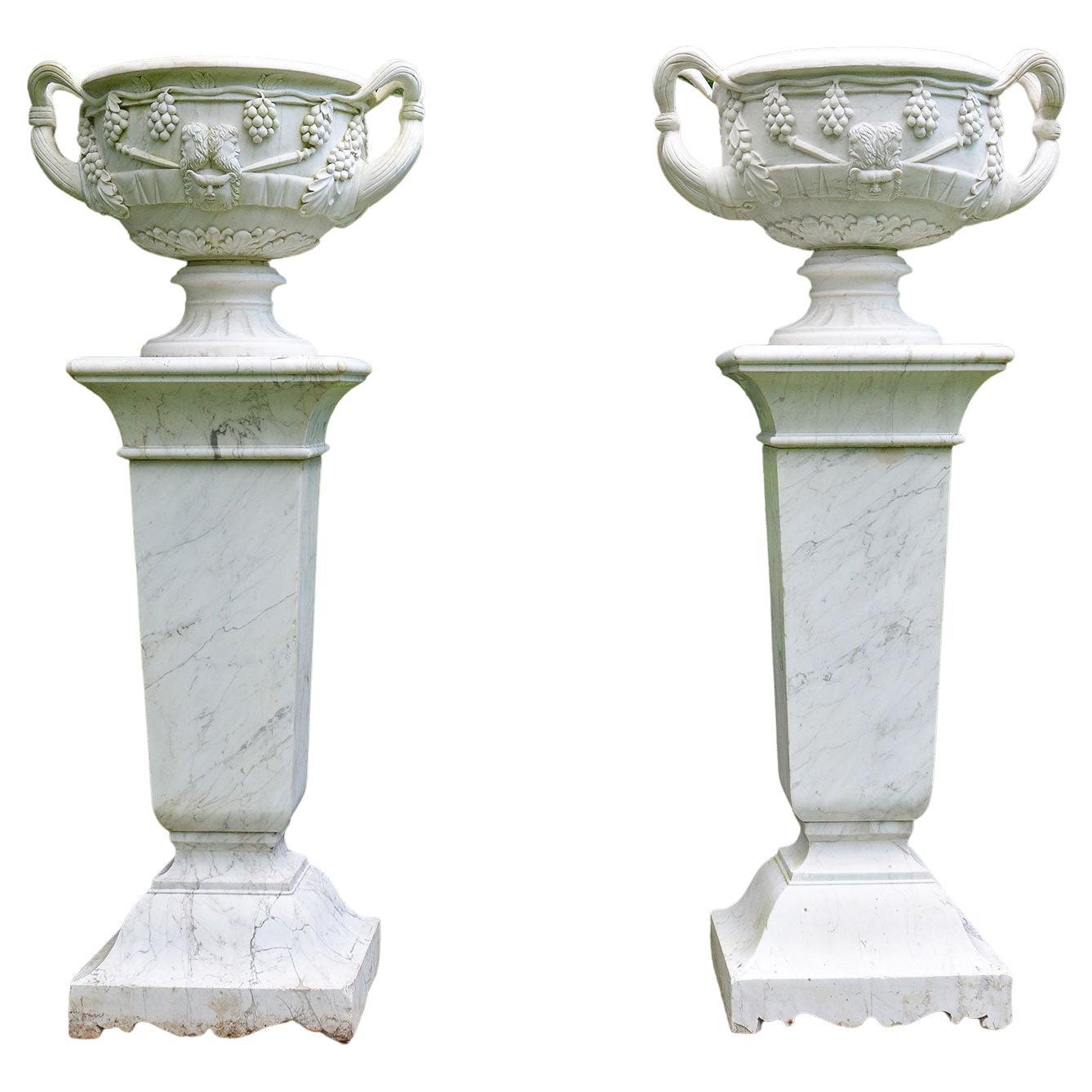 Paire d'urnes en marbre blanc sur de grands piédestaux en marbre blanc